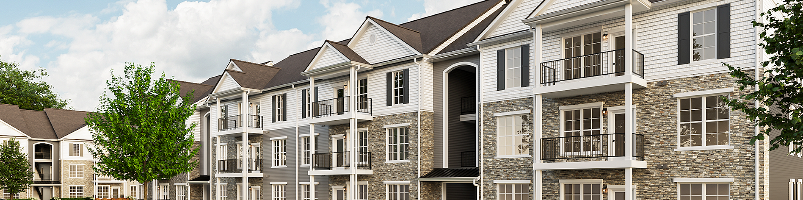 Charming modern apartment complex with elegant stone facade, spacious balconies, and lush greenery beneath a vibrant blue sky.
