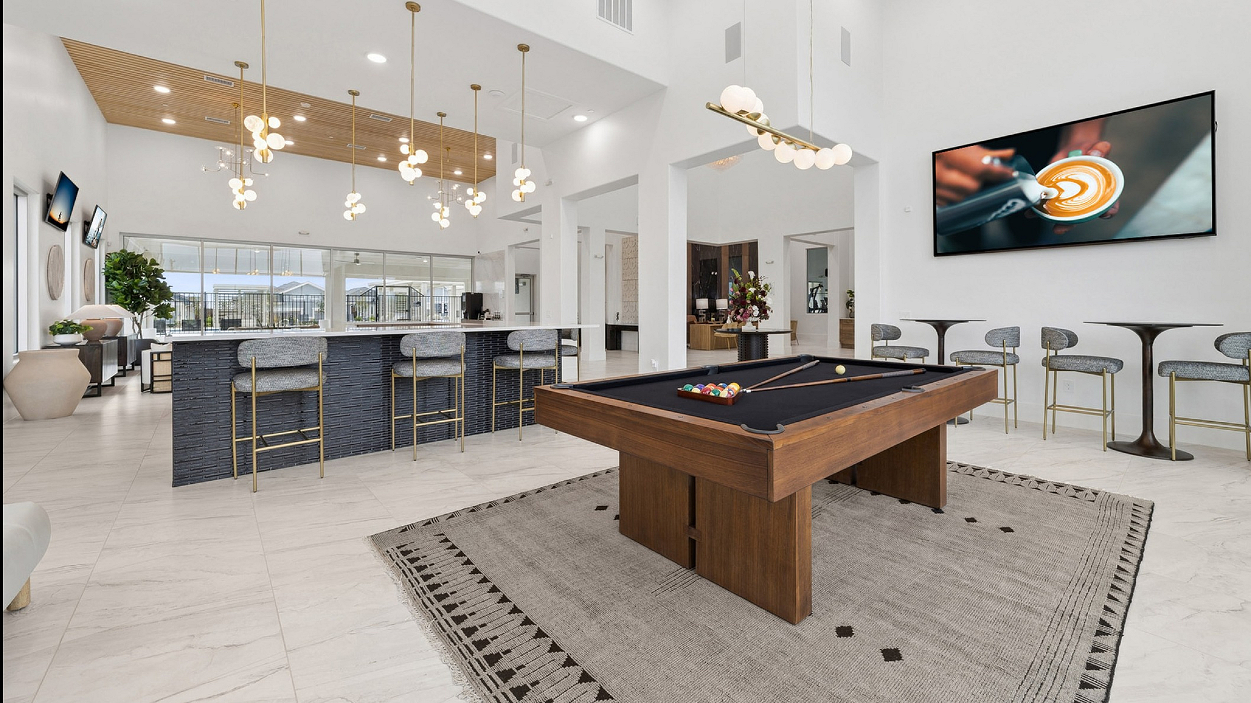 Luxurious open-concept living space featuring a chic bar area with elegant lighting, plush seating, and a stylish pool table for entertainment.