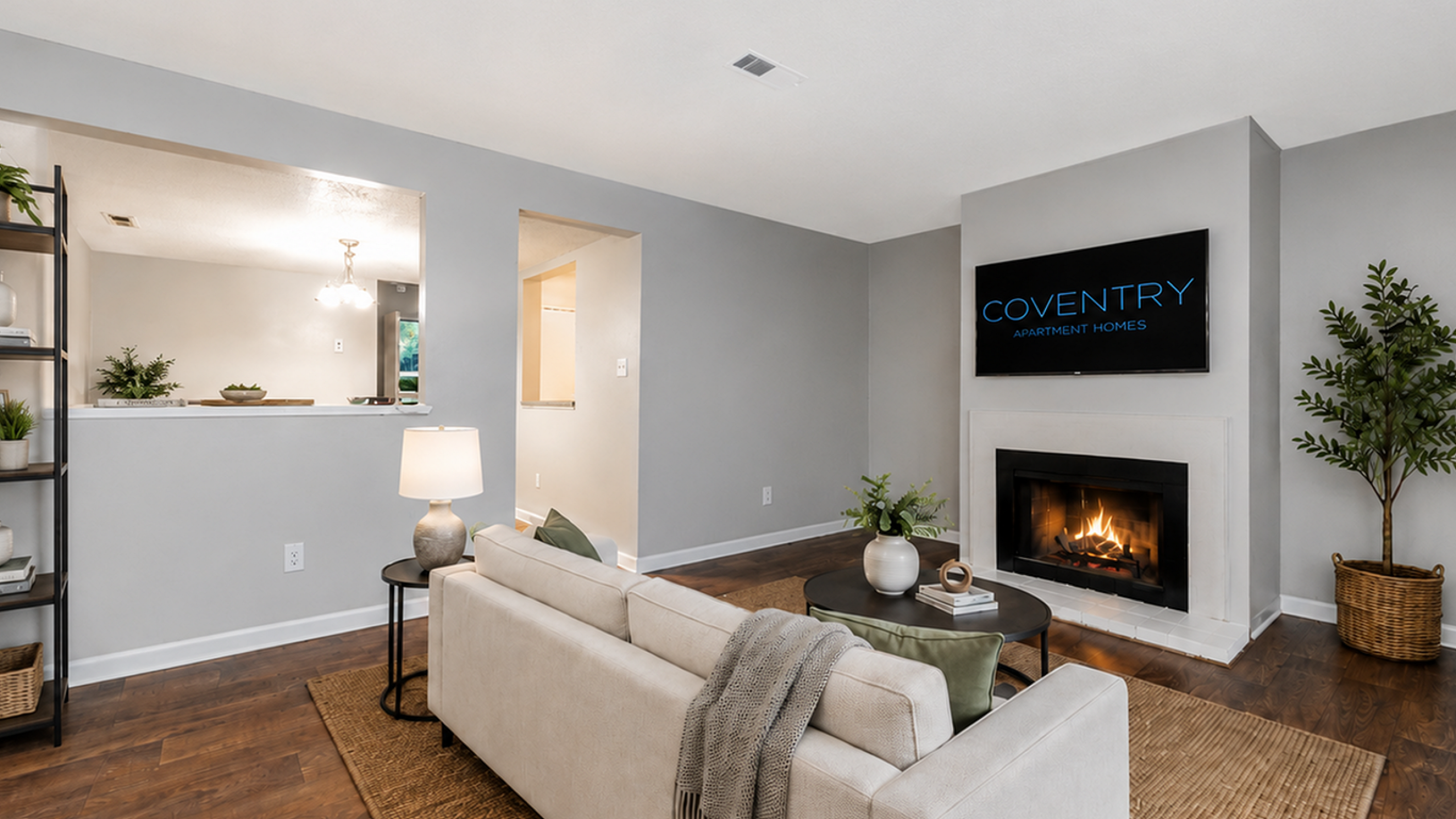 Inviting living room with a cozy fireplace, modern decor, and wooden flooring at Coventry Apartment Homes.