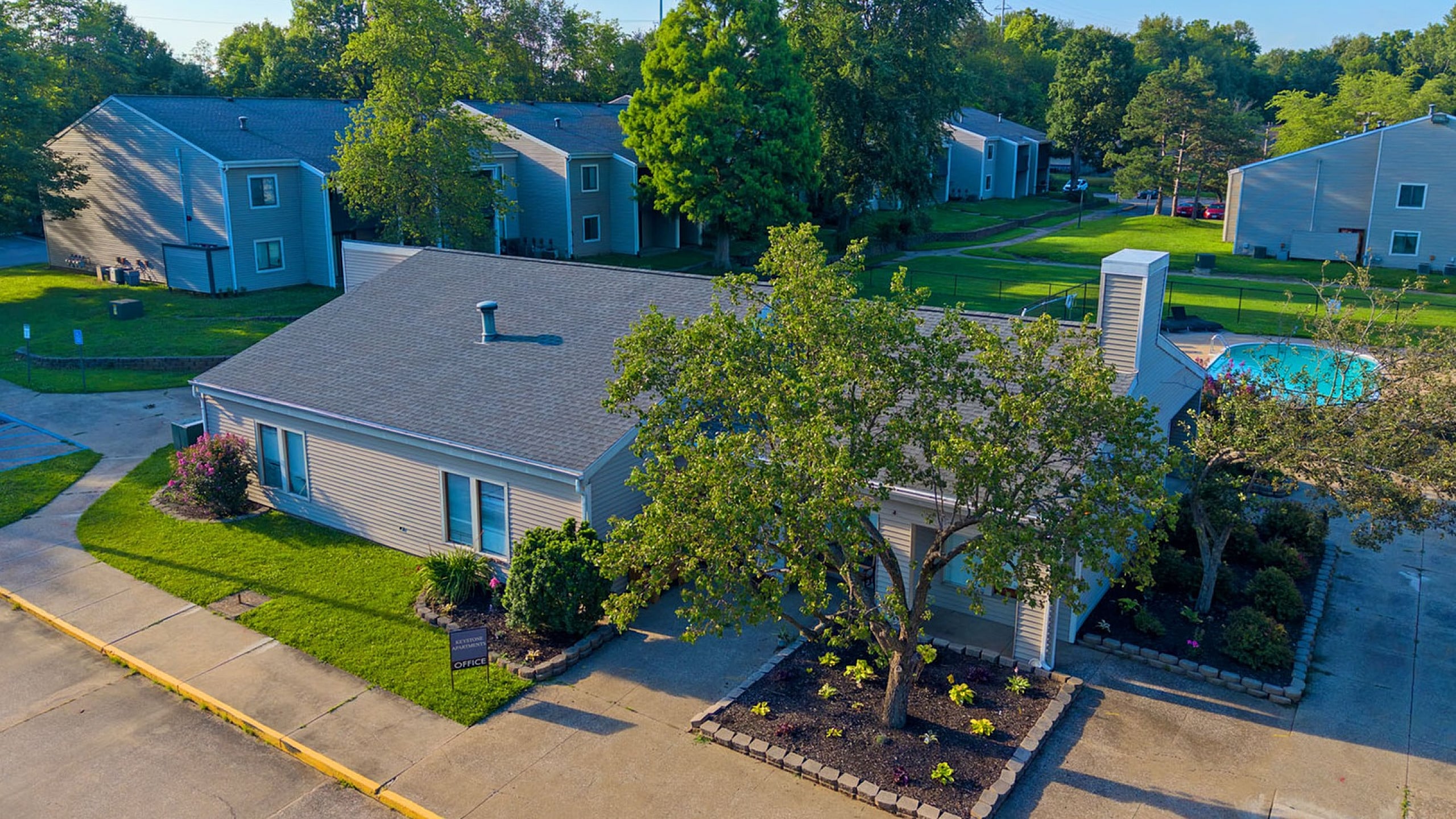 Charming apartment complex with lush greenery, modern design, and inviting outdoor pool area, perfect for relaxation and community living.