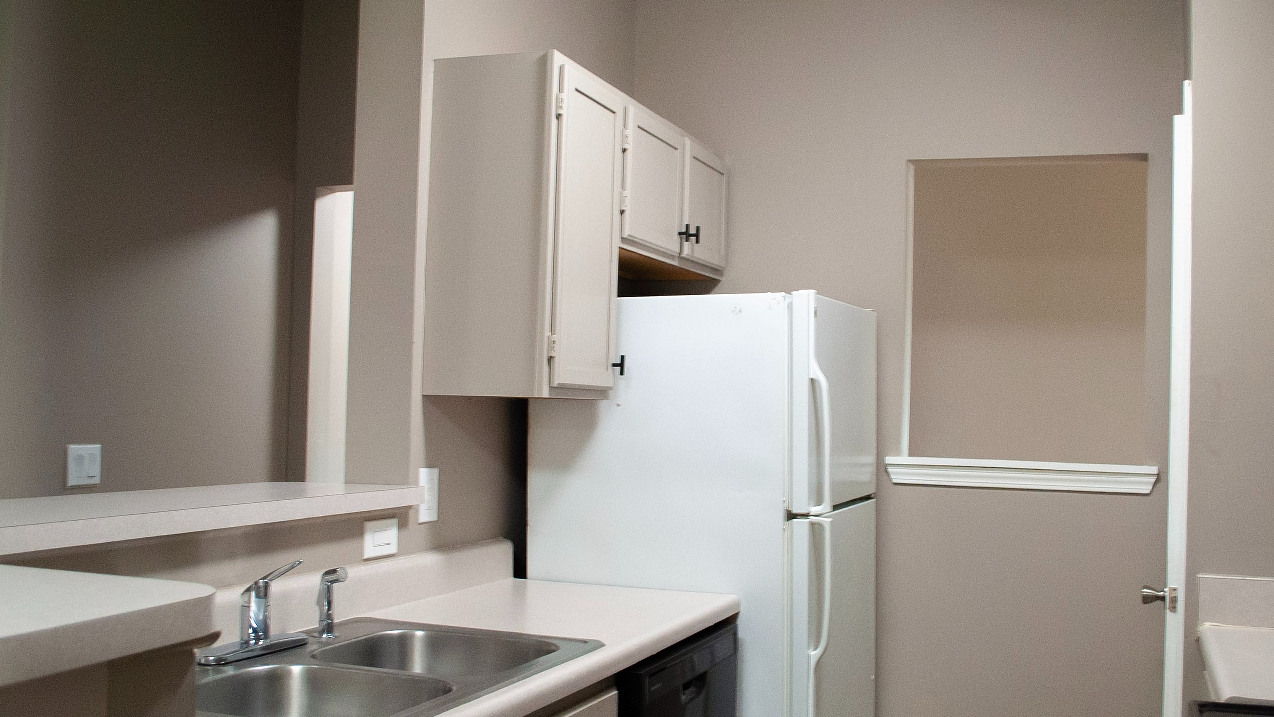 Modern kitchen with sleek countertops, double sink, and ample cabinetry, perfect for culinary enthusiasts.