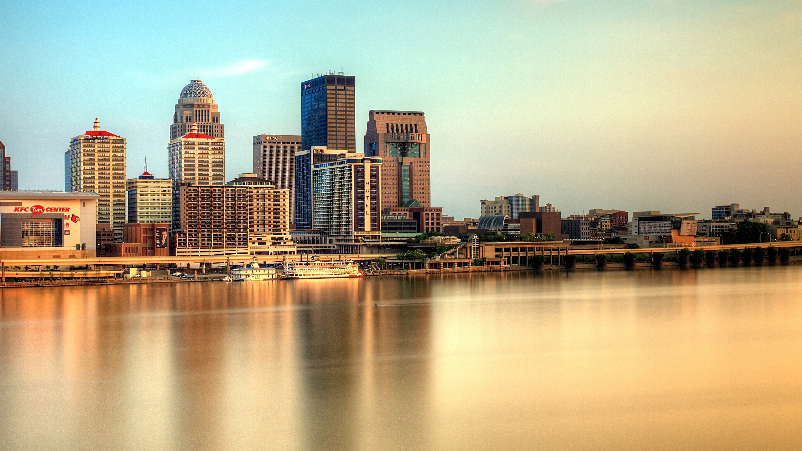 Breathtaking city skyline view at sunset, showcasing modern skyscrapers and tranquil waterfront reflections.