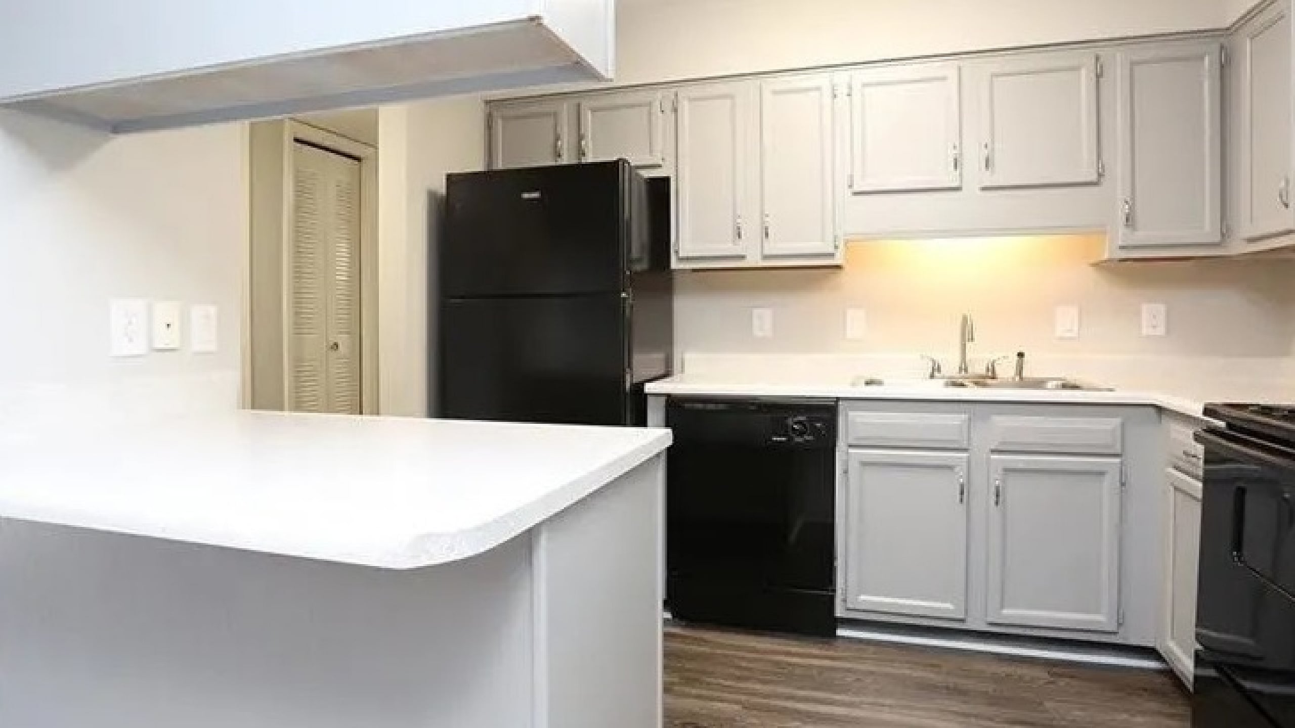 Bright and modern kitchen with sleek gray cabinetry, spacious countertops, and stylish lighting.