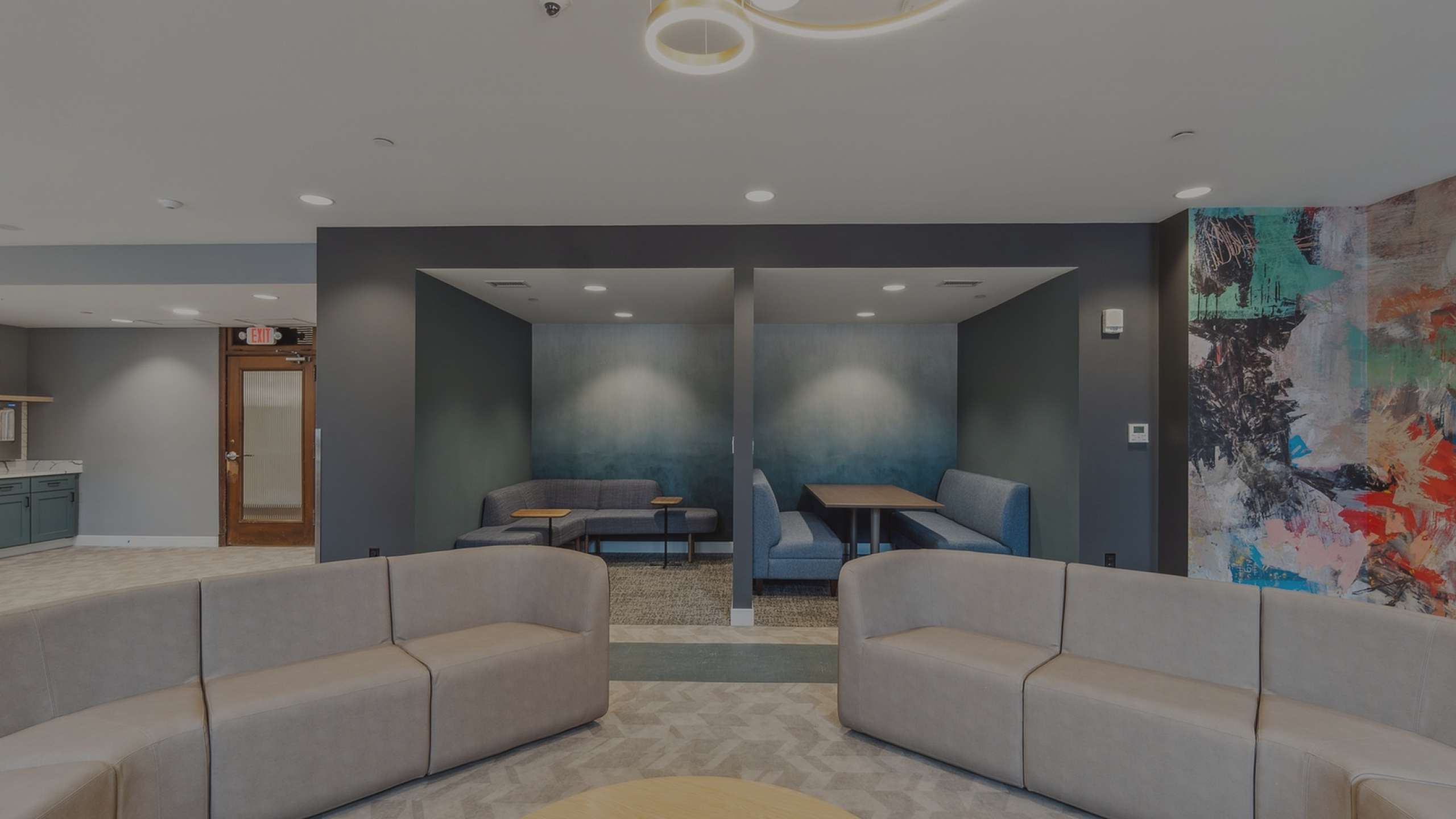Contemporary lounge area with stylish seating, artistic wall mural, and intimate seating nooks, perfect for relaxation and socializing.