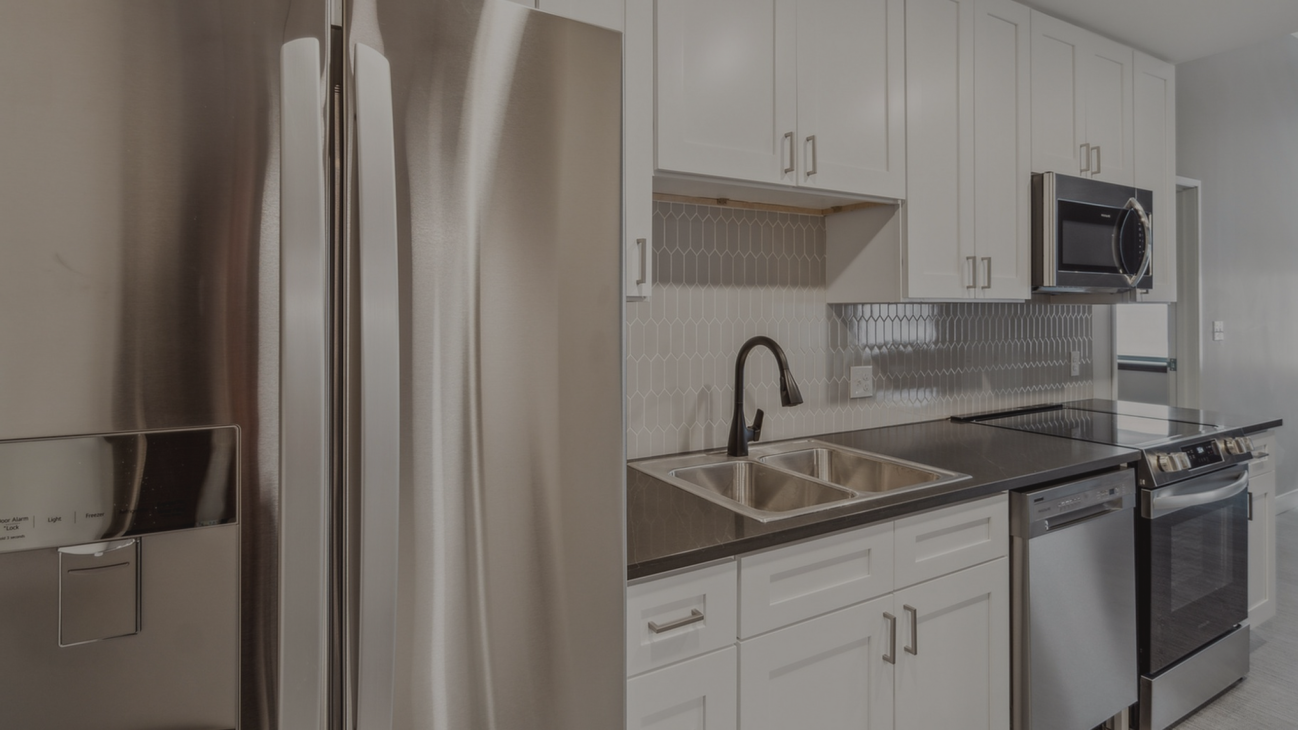 Modern kitchen with sleek stainless steel appliances, elegant cabinetry, and a stylish hexagonal tile backsplash.