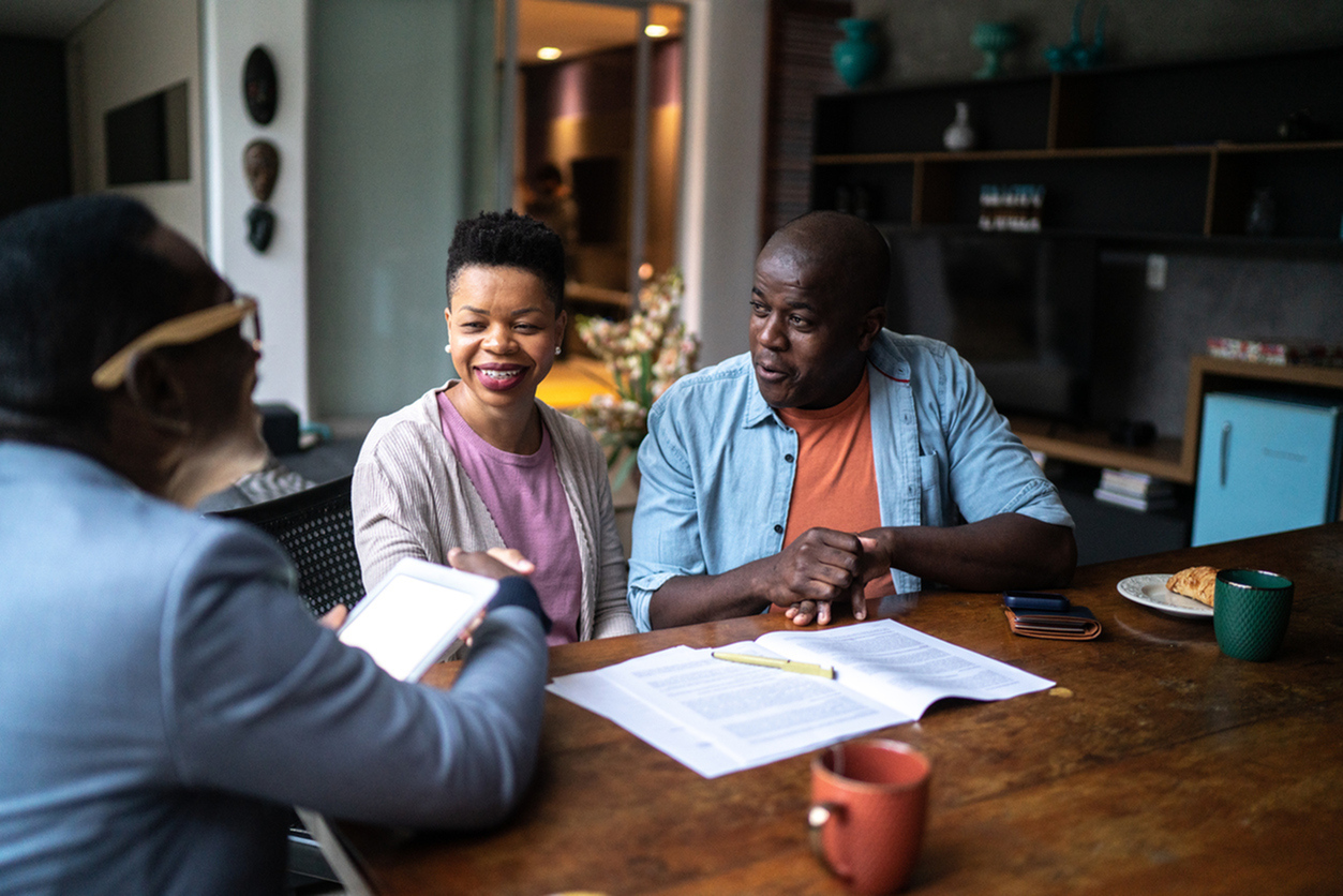 Couple shaking hand with real estate agent setting a deal