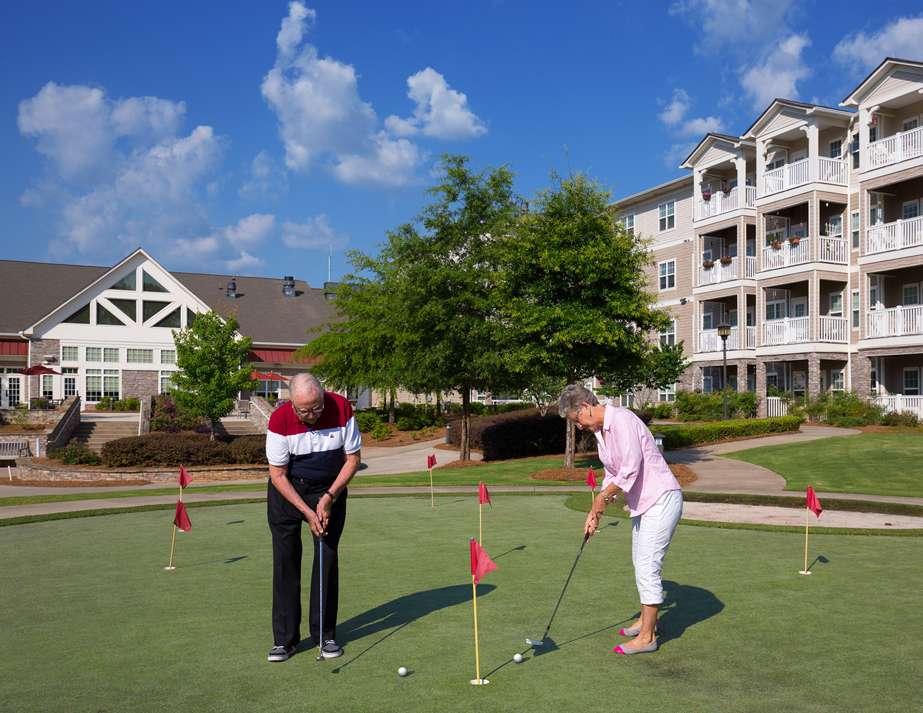 Two BridgeMill residents phaving fun while putting on The Lodge at BridgeMill's golf putting greens