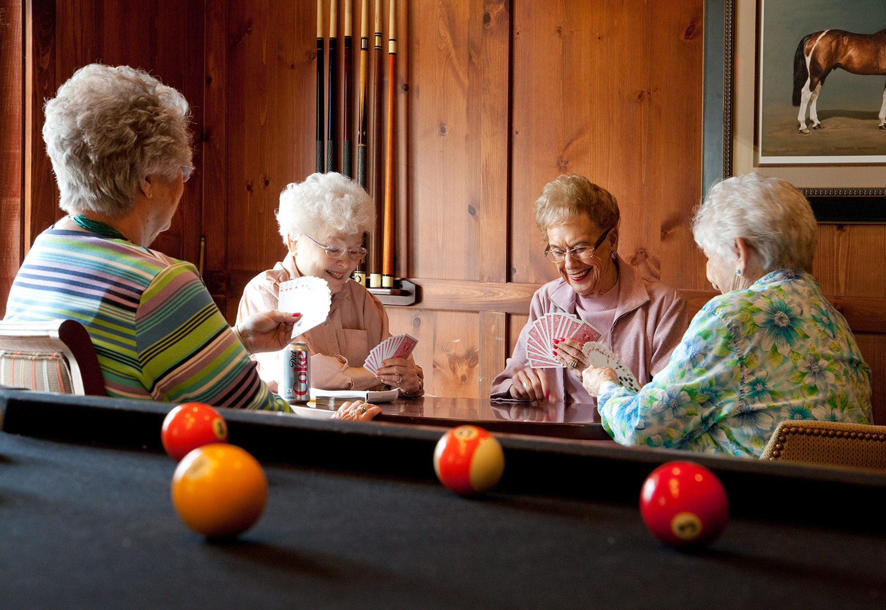 A group of residents sitting together playing cards in front of a pool table