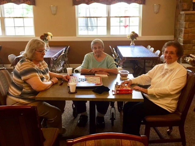 Residents sitting at a table , smiling at the camera