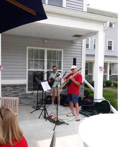 Two Pinnacle residents having fun while putting on a show, playing musical instruments outside