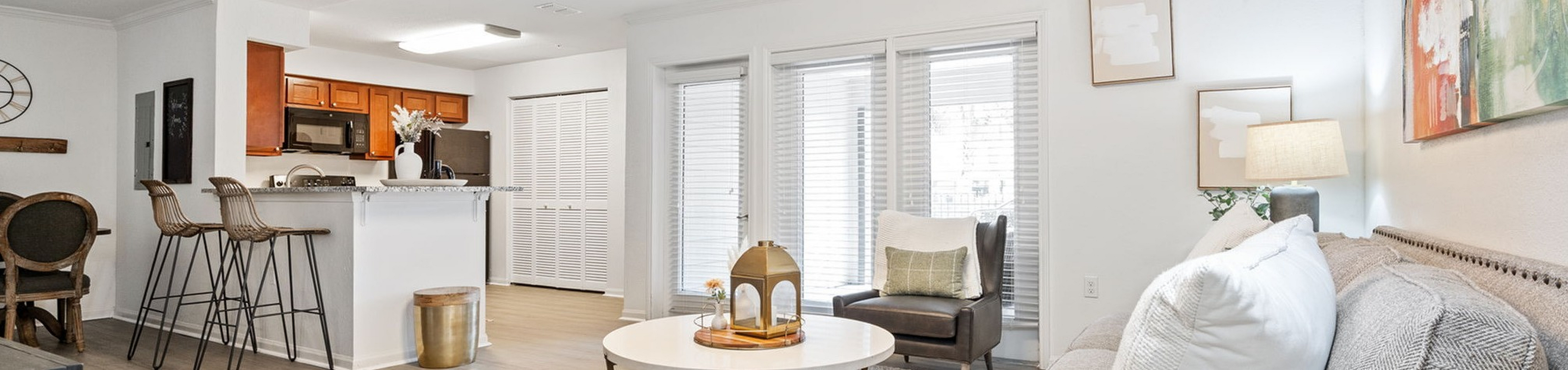 Inviting open-concept living space with modern kitchen, cozy seating area, and abundant natural light accentuating stylish decor.