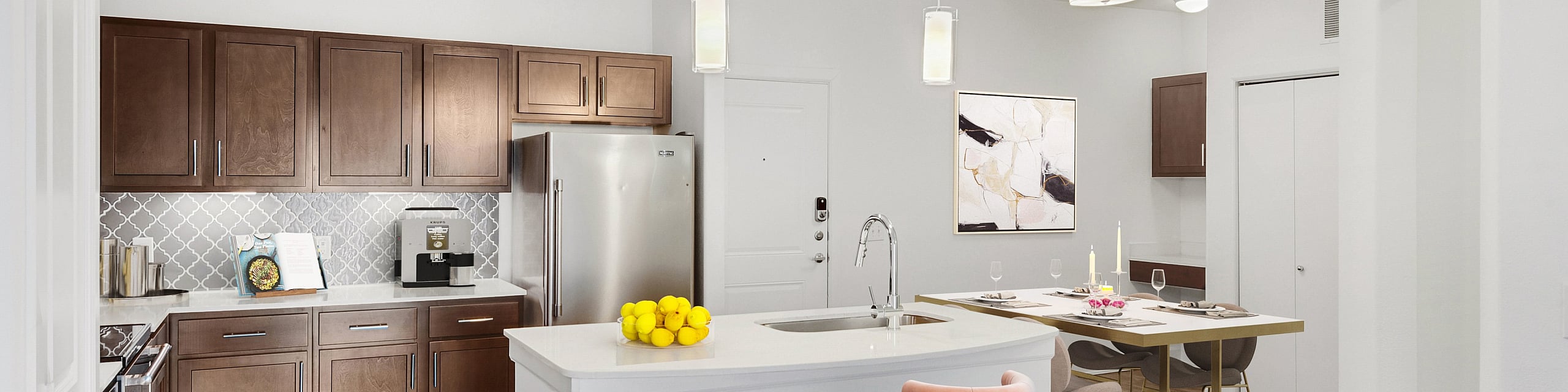 Elegant modern kitchen and dining area featuring sleek cabinetry, stainless steel appliances, and chic pendant lighting. Cozy island with pink bar stools and a stylish dining table setting enhance the ambiance.