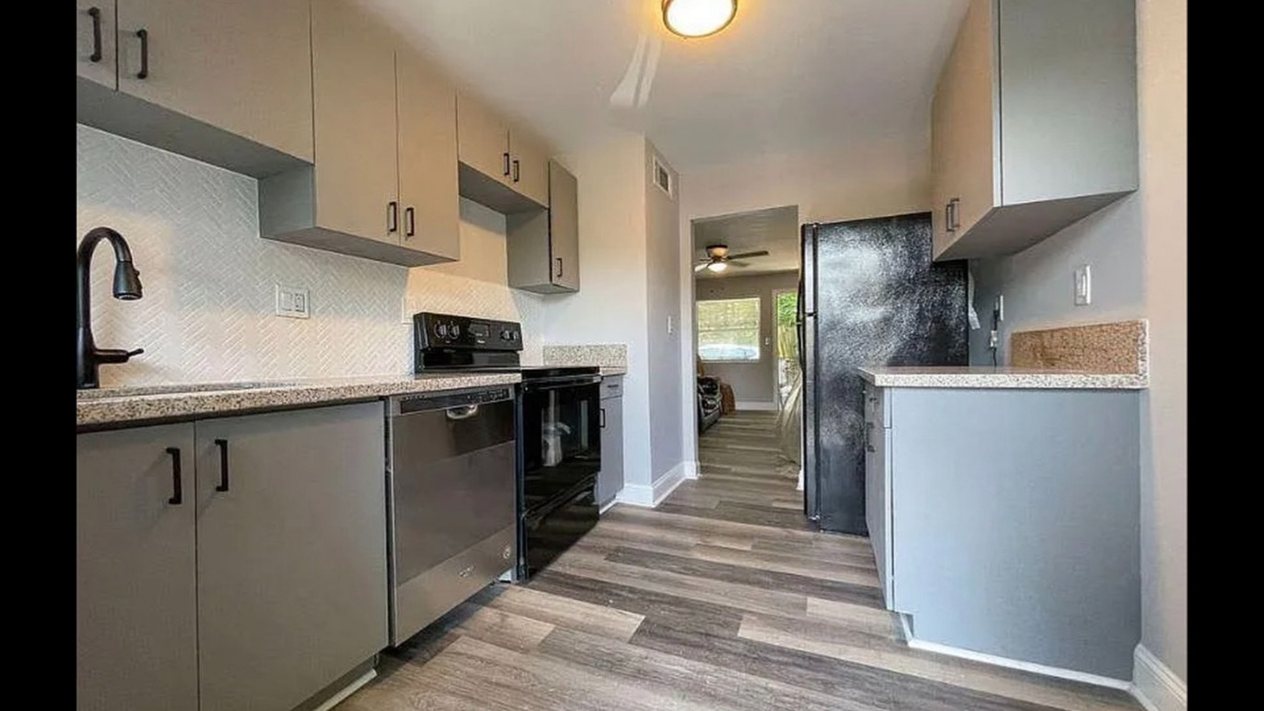 Modern kitchen with sleek cabinetry, stainless steel appliances, and elegant wood flooring creating a warm and inviting atmosphere.