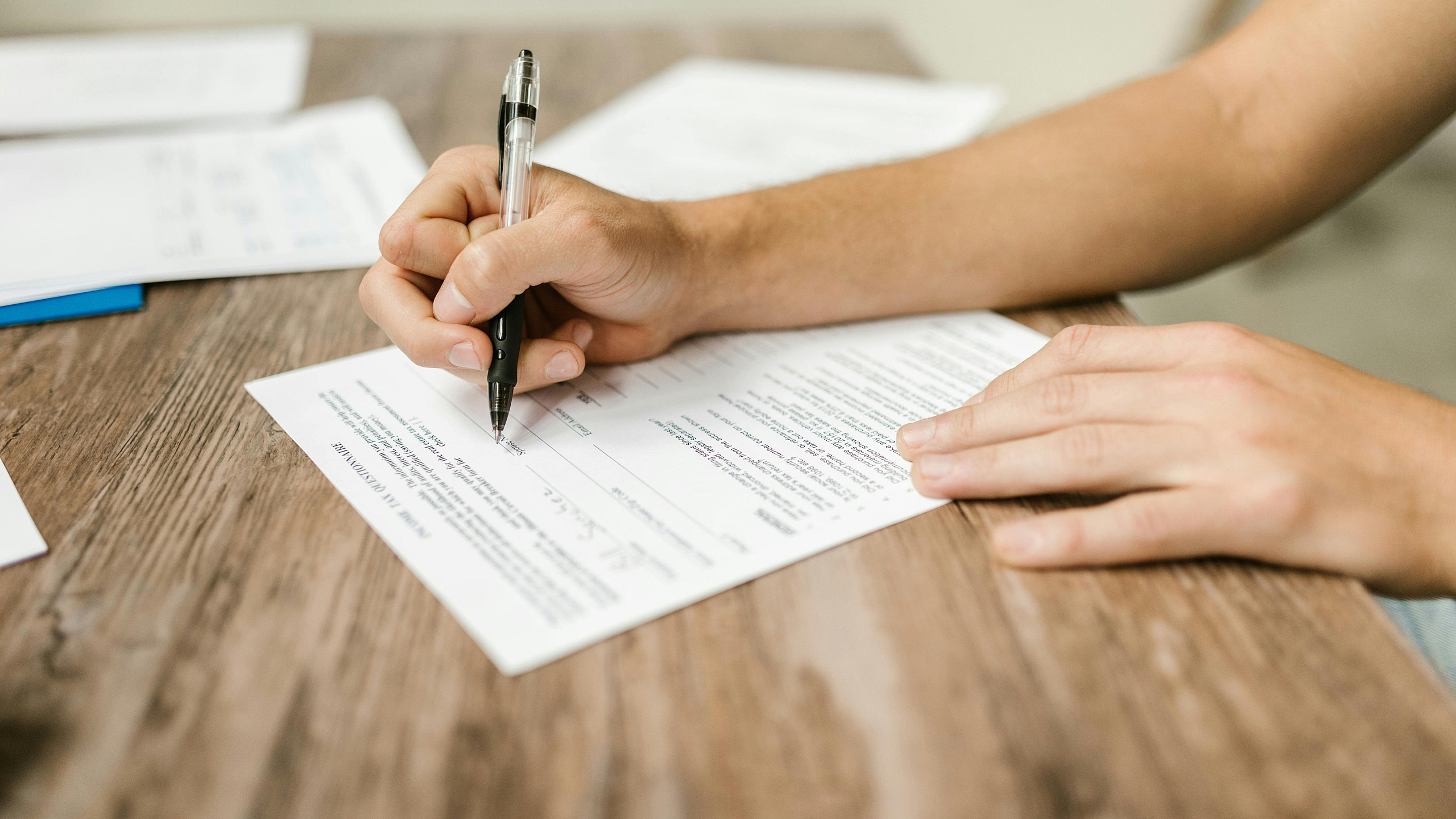 close-up-shot-of-a-person-filling-out-a-form