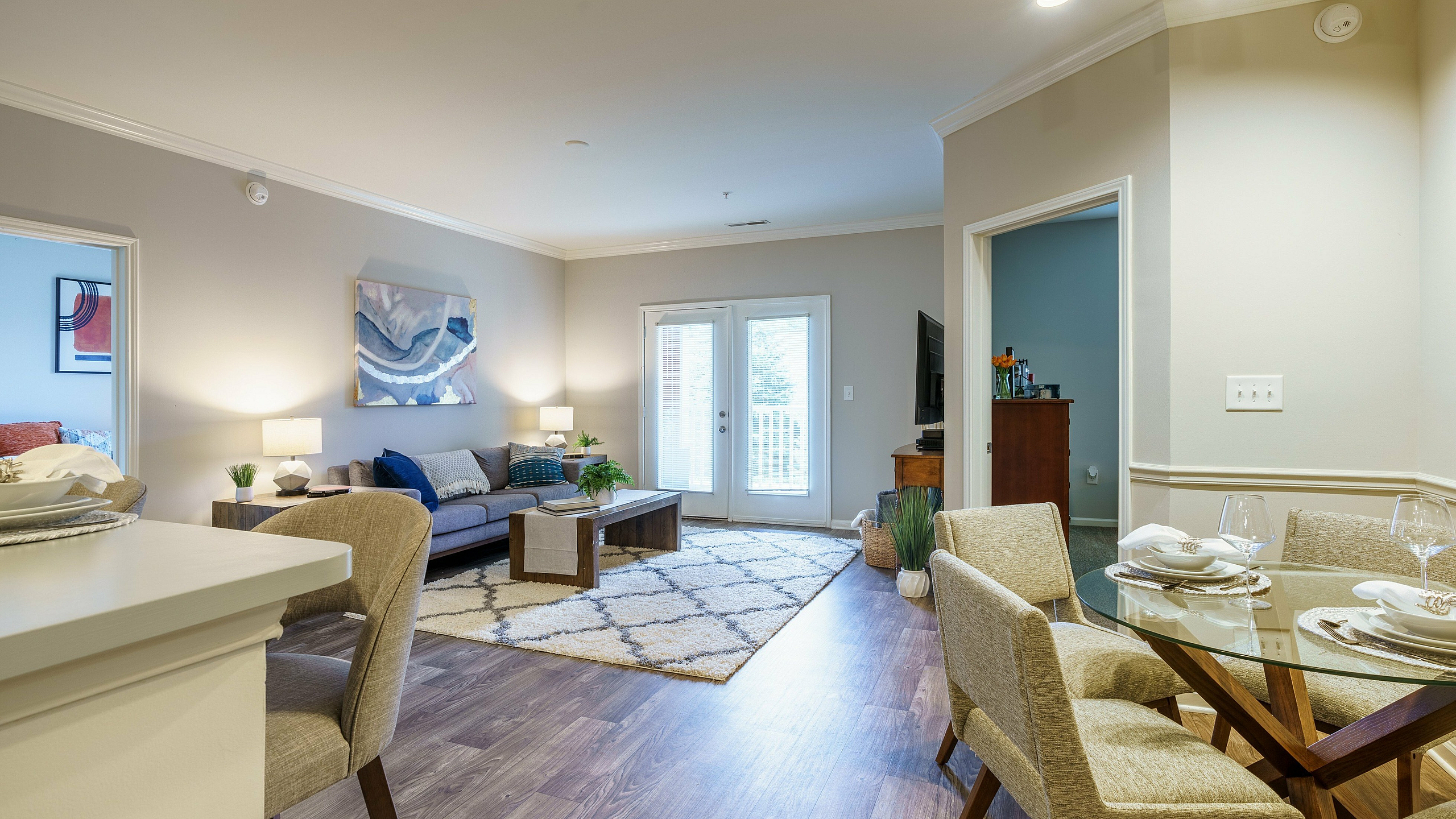 Inviting open-plan living room with a cozy seating area, stylish dining set, and bright natural light.