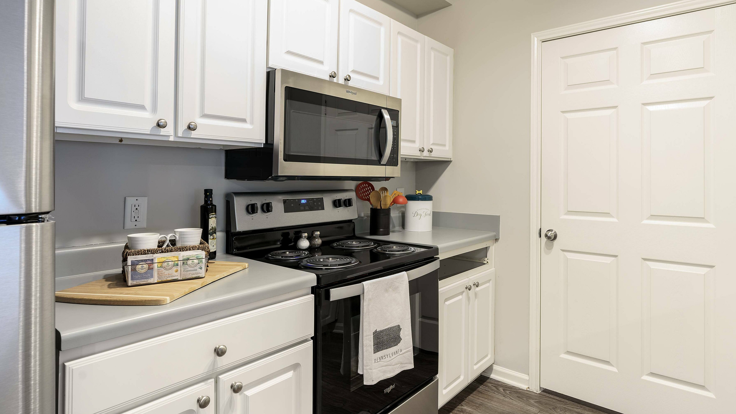 Contemporary kitchen with stainless steel appliances, white cabinetry, and elegant countertops.