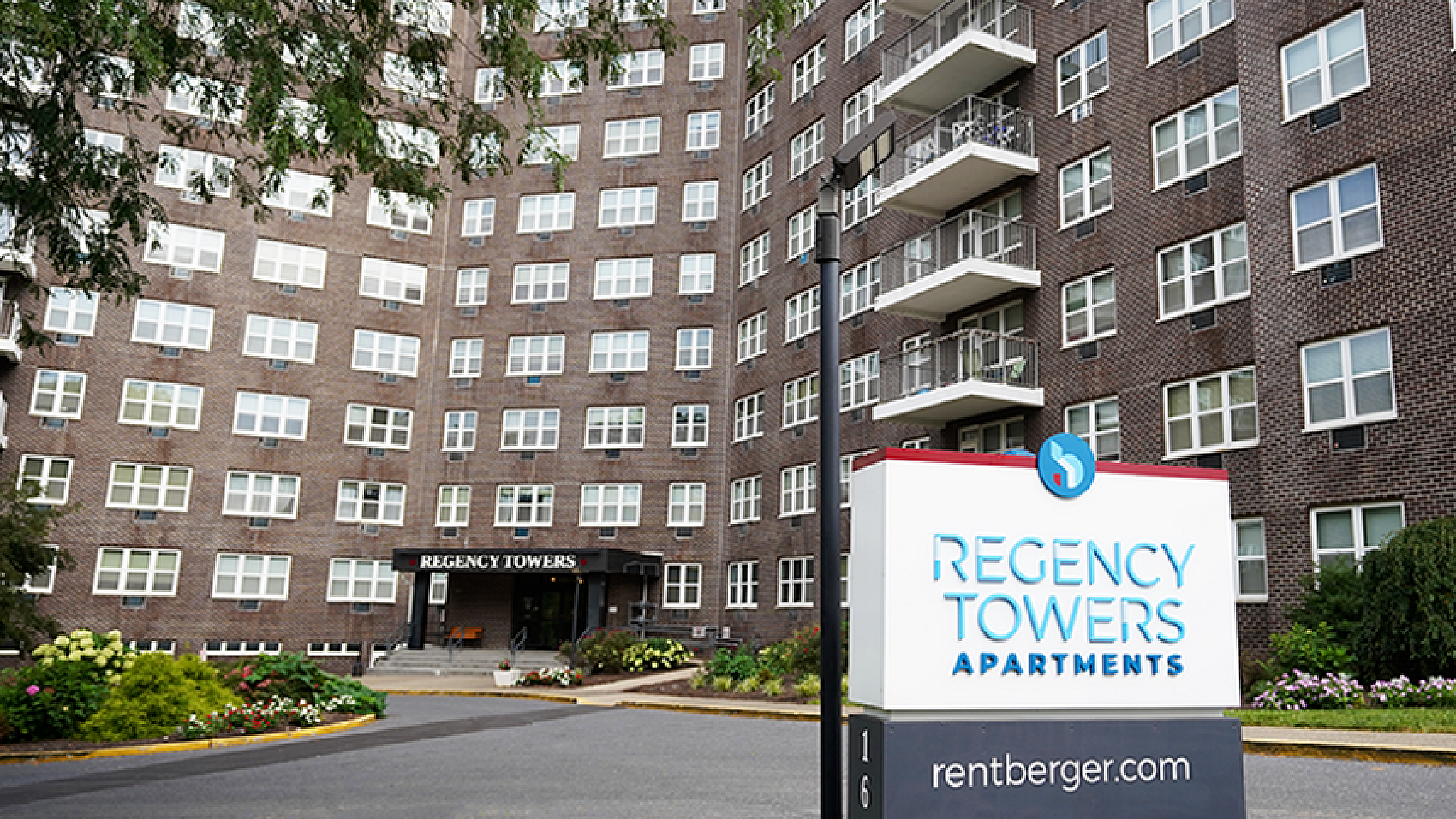 Inviting exterior view of Regency Towers Apartments, showcasing modern architecture and lush landscaping.