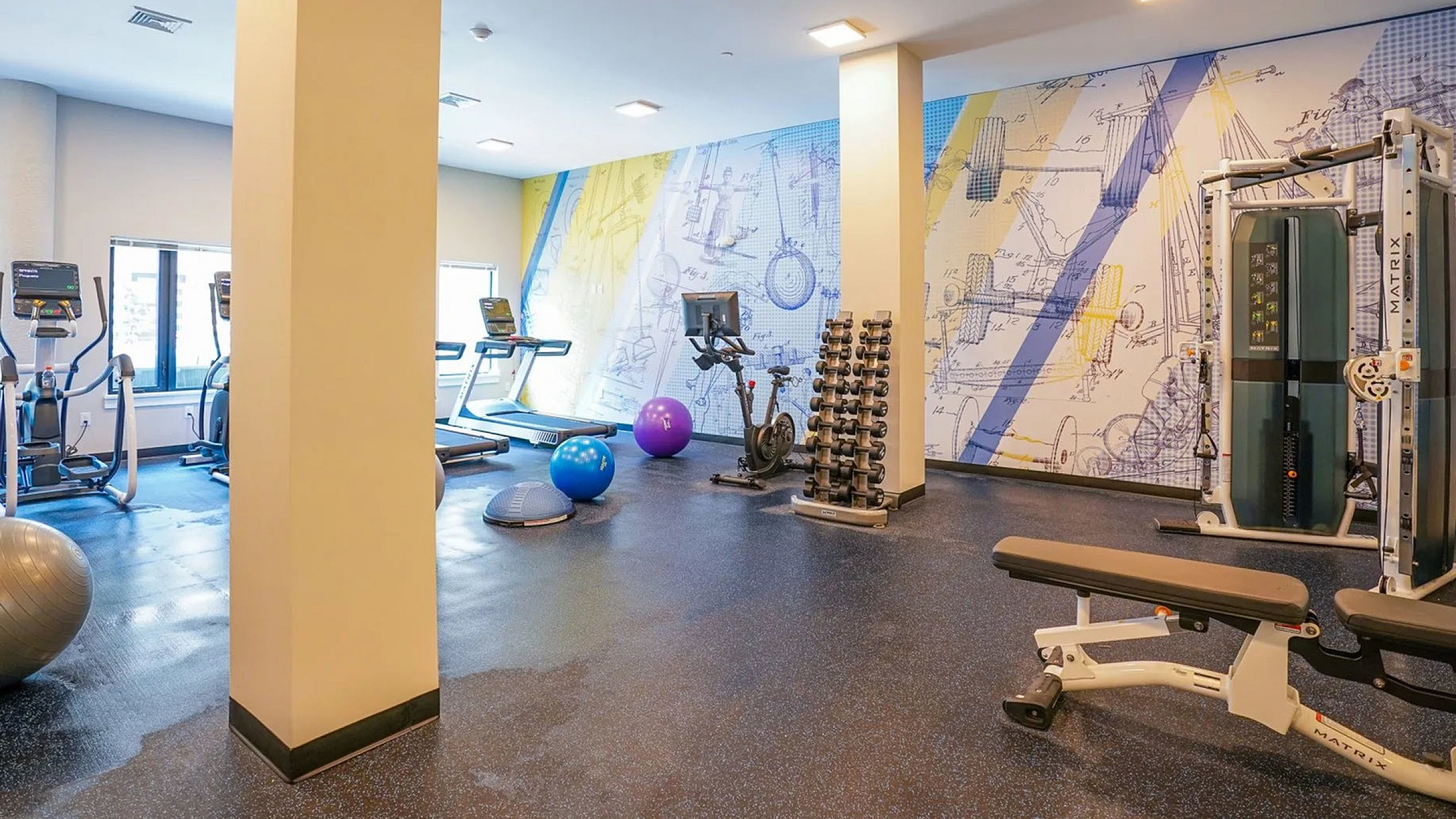 Contemporary fitness center with modern gym equipment and vibrant wall art, perfect for an energizing workout.
