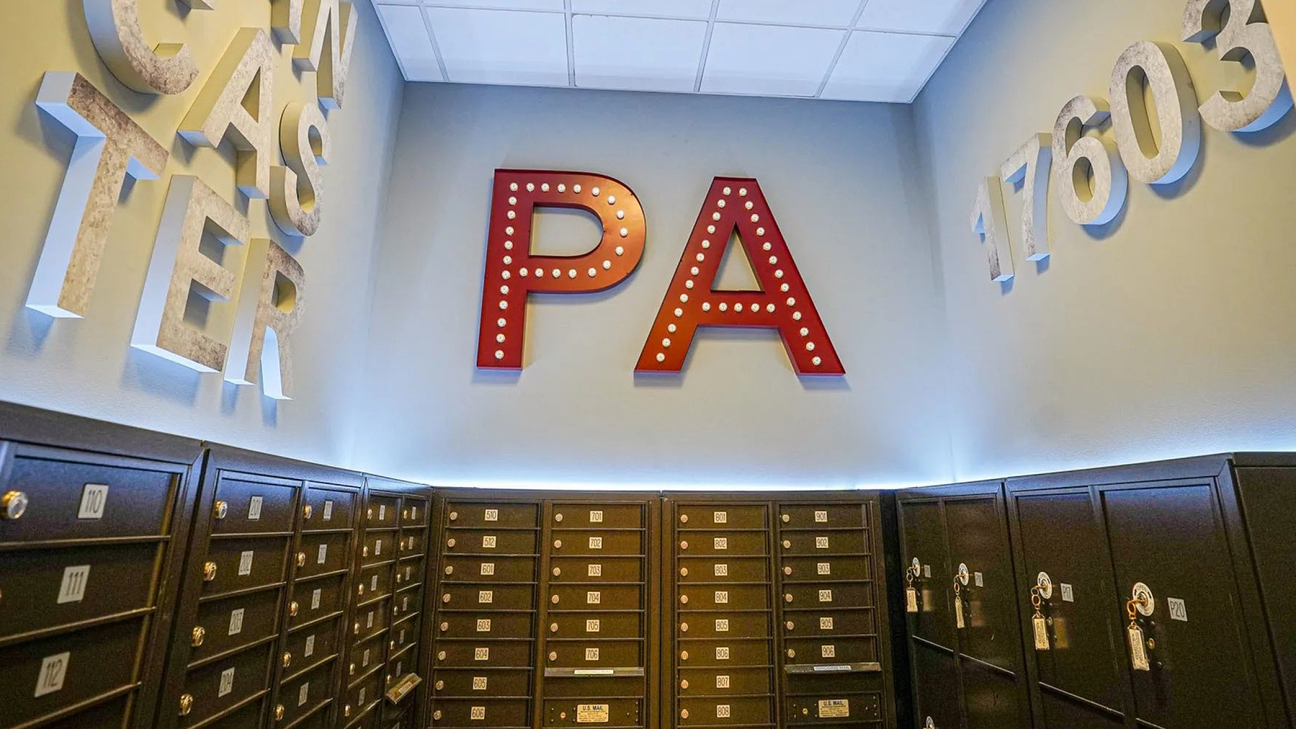 Vibrant lobby with bold decorative letters, sleek mailboxes, and stylish lighting in a contemporary apartment complex.