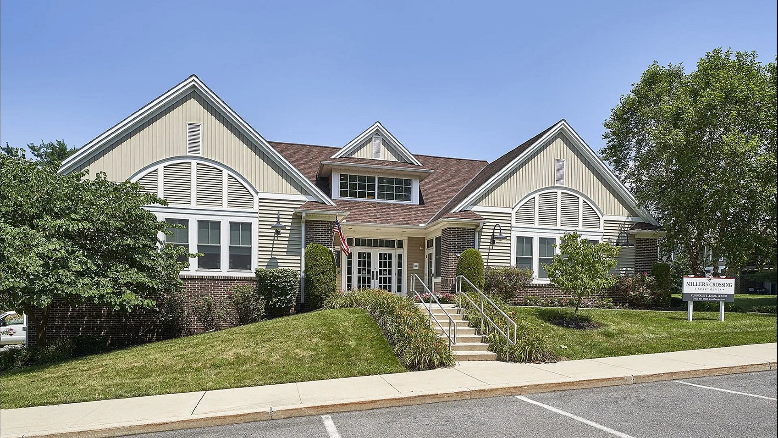 Charming residential building with a welcoming entrance, manicured lawns, and a classic architectural design at Millers Crossing Apartments.