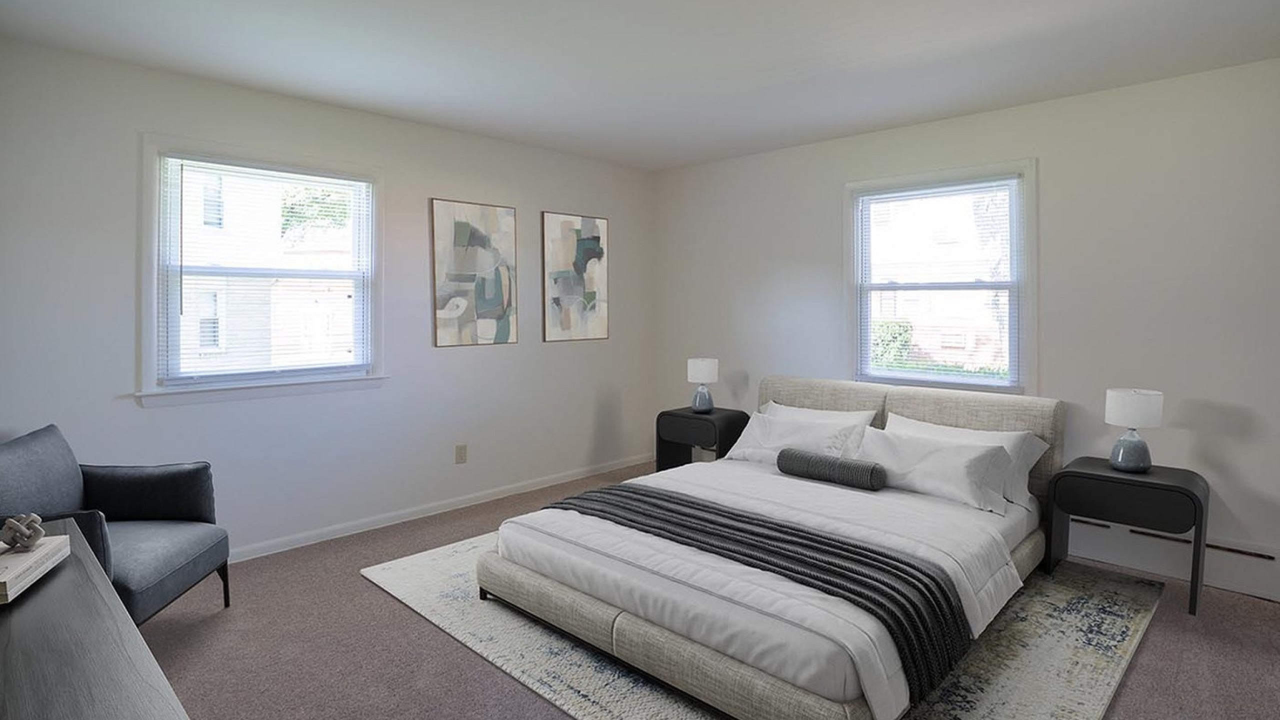 Bright and elegant bedroom with modern decor, featuring large windows, stylish artwork, and a plush bed for ultimate comfort.