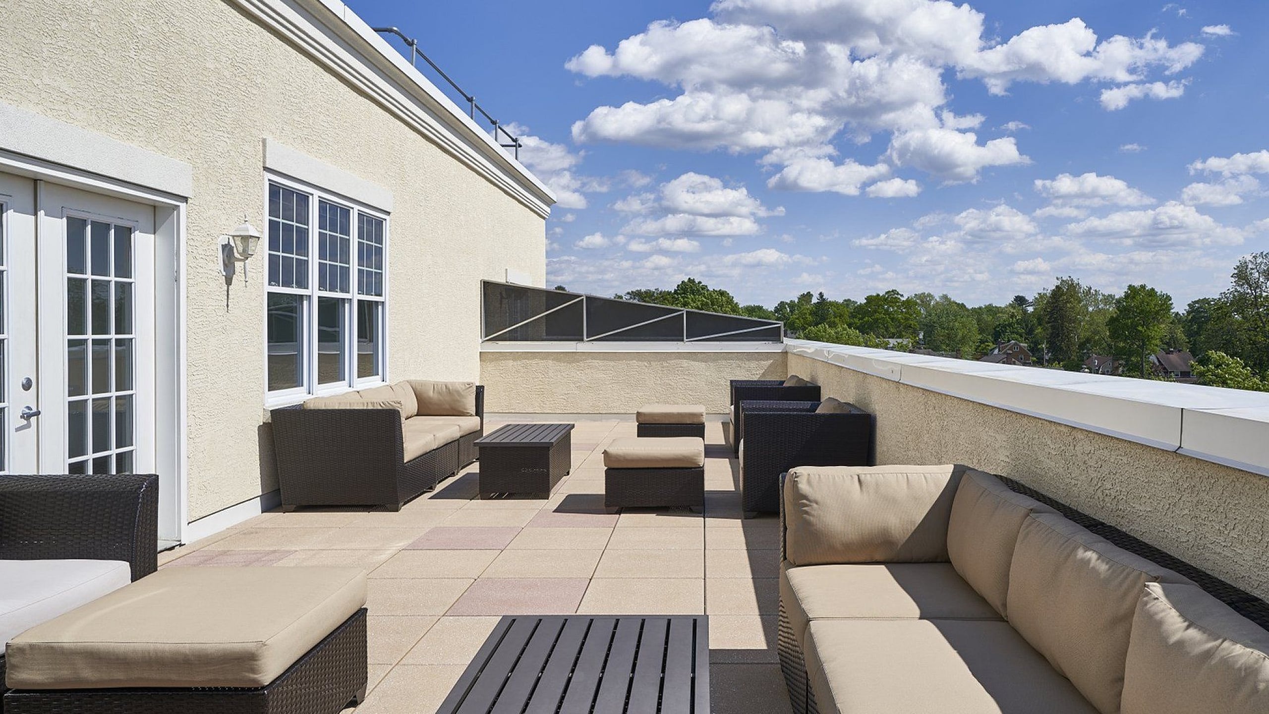 Luxurious rooftop terrace with comfortable seating and expansive views under a clear blue sky.