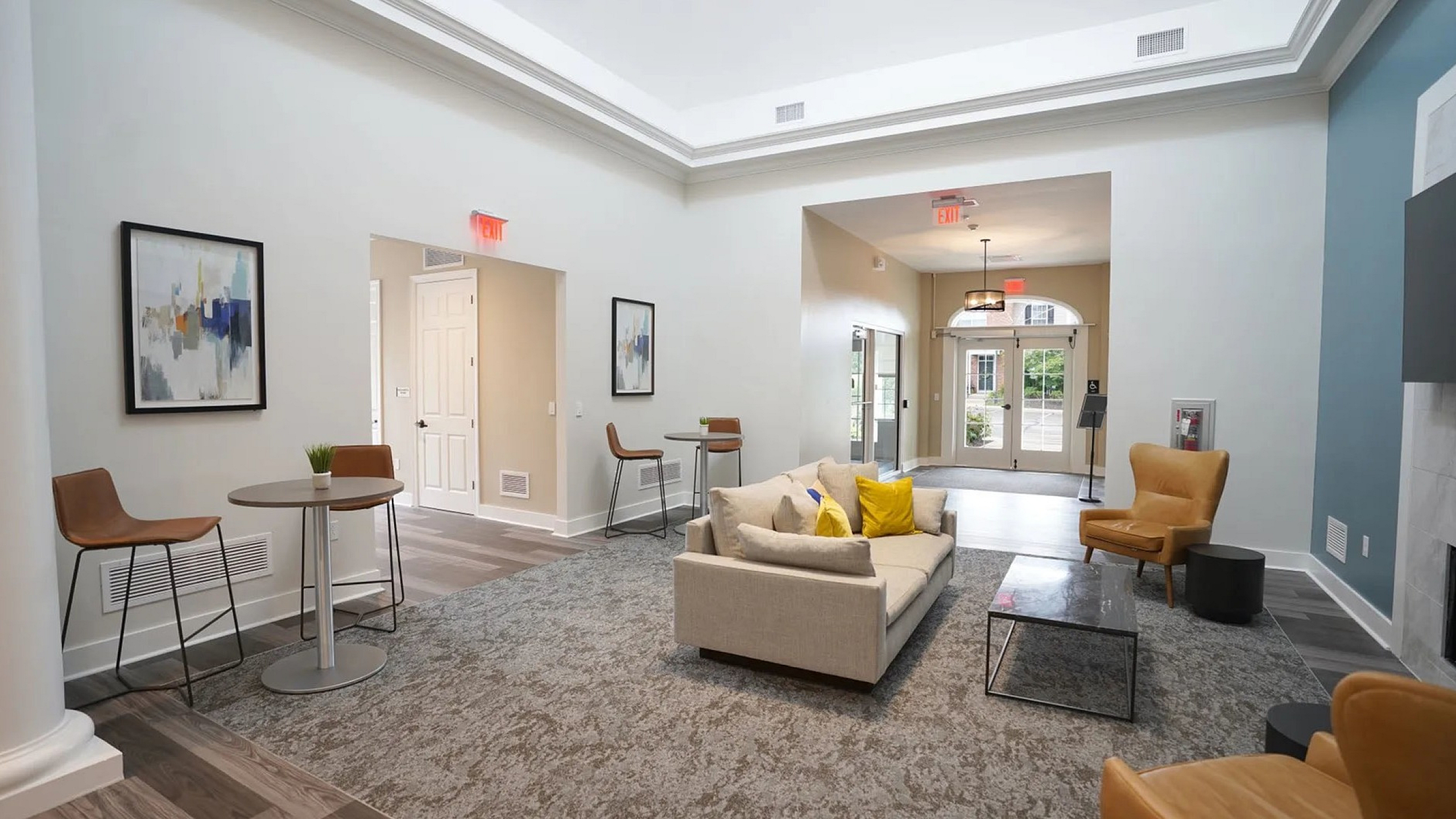 Inviting living space with modern decor, cozy seating, and natural light, featuring stylish design elements and plush carpeting.