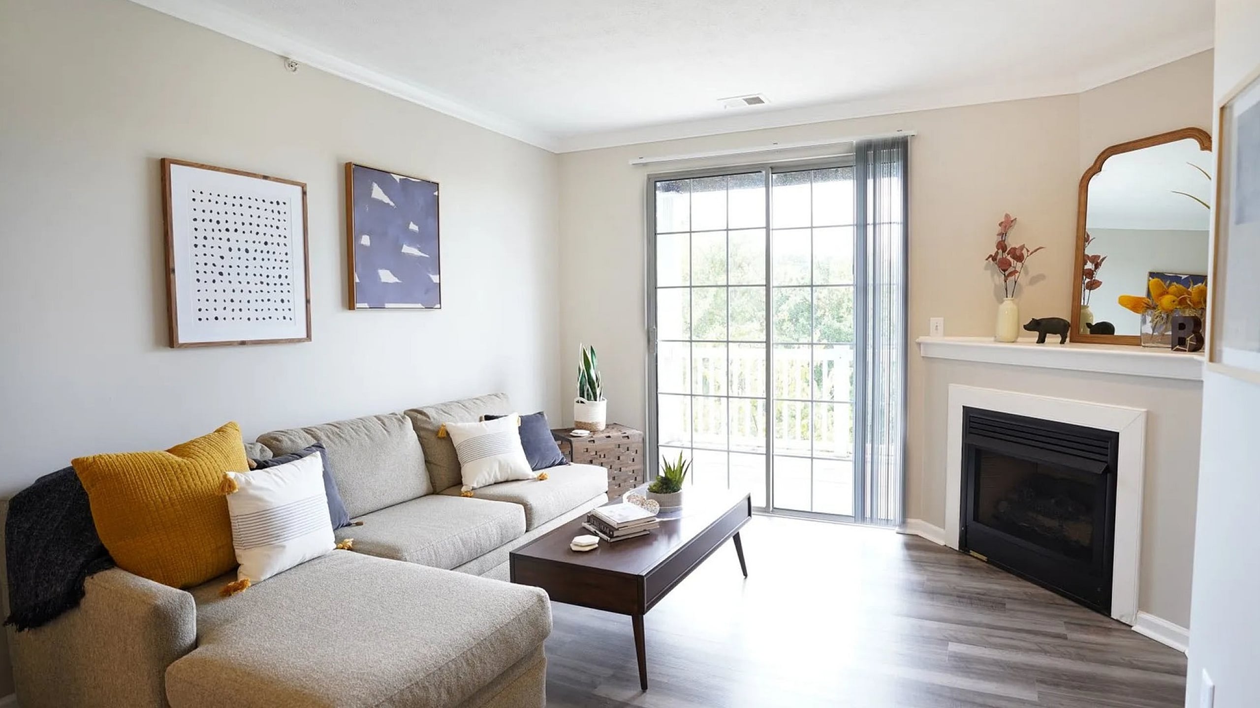 Bright and inviting living room featuring a cozy sectional sofa, elegant fireplace, and large windows providing natural light.