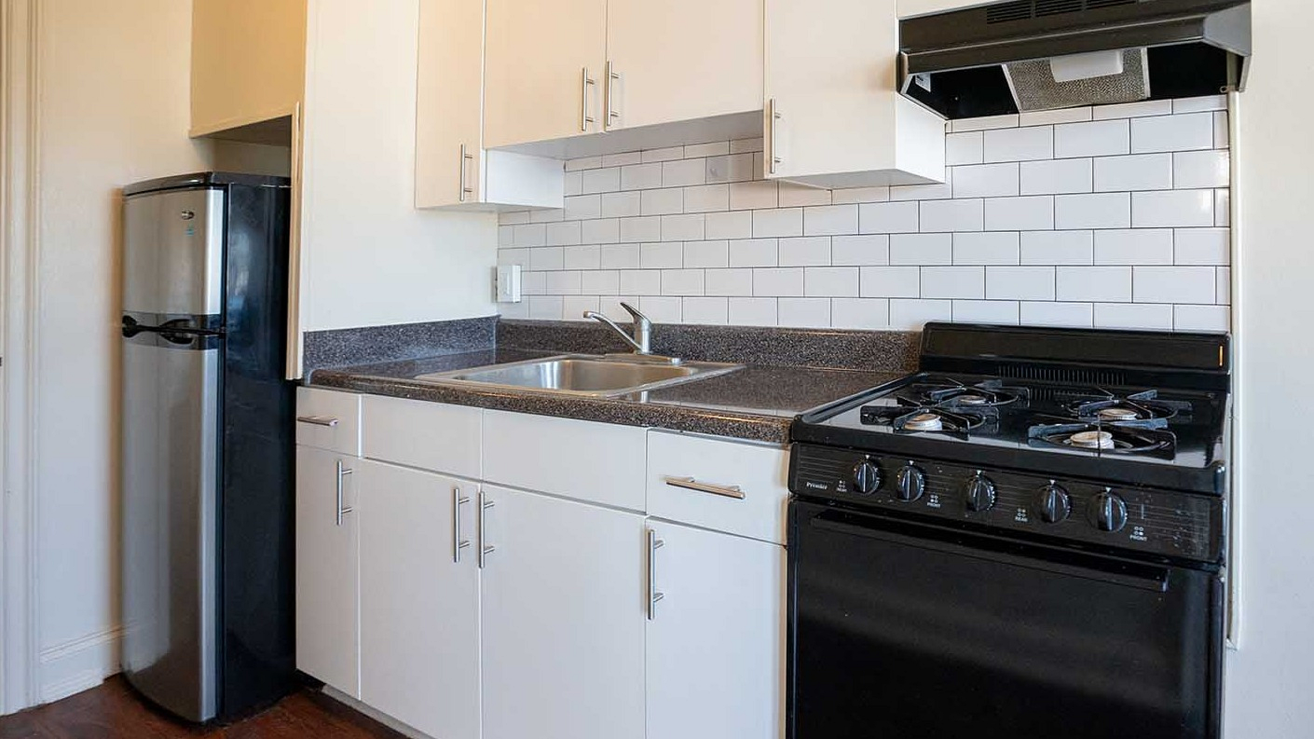 Modern kitchen with sleek stainless steel appliances, stylish white cabinets, and chic subway tile backsplash.