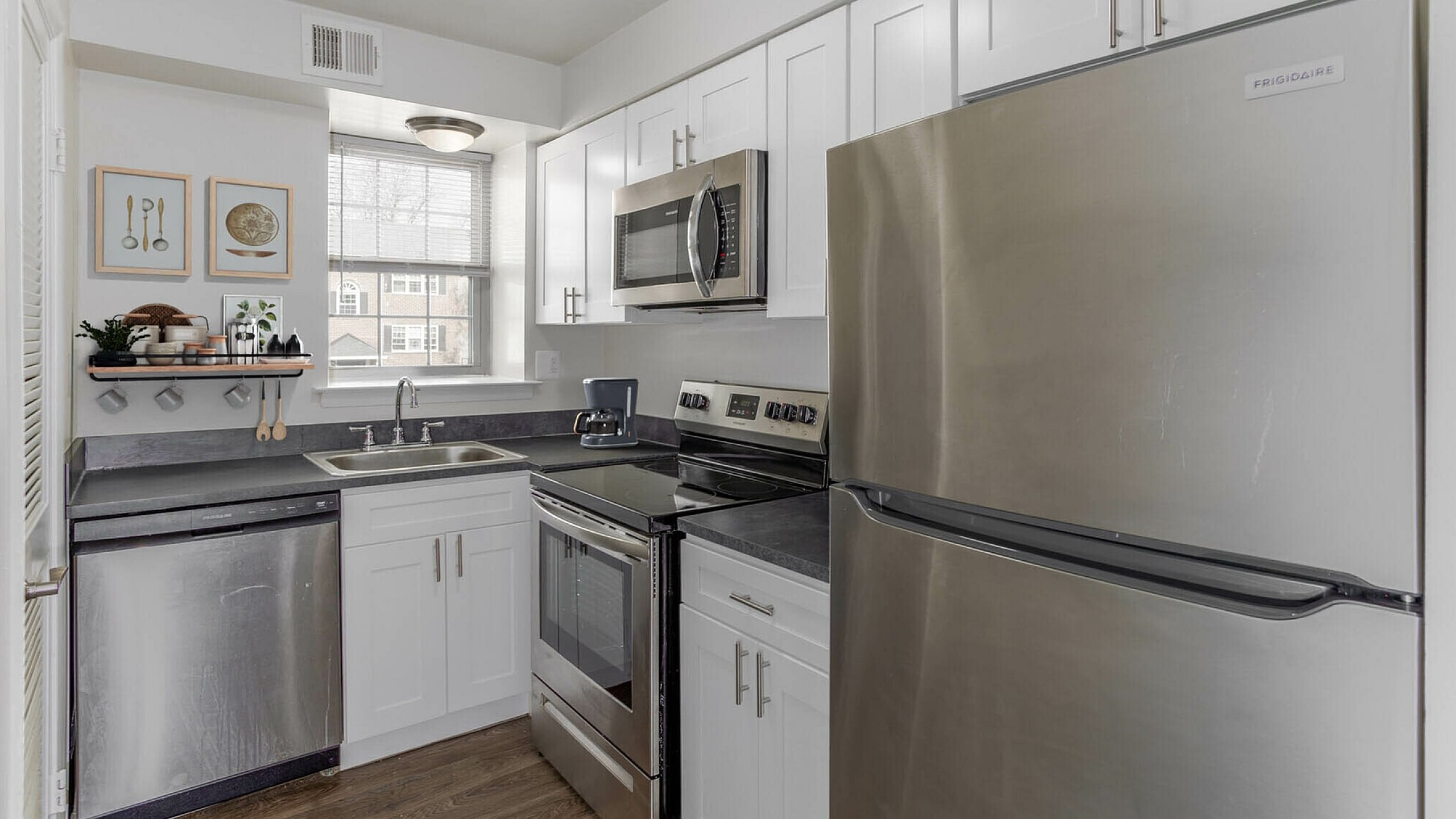 Modern kitchen featuring sleek stainless steel appliances, white cabinetry, and a stylish countertop design.