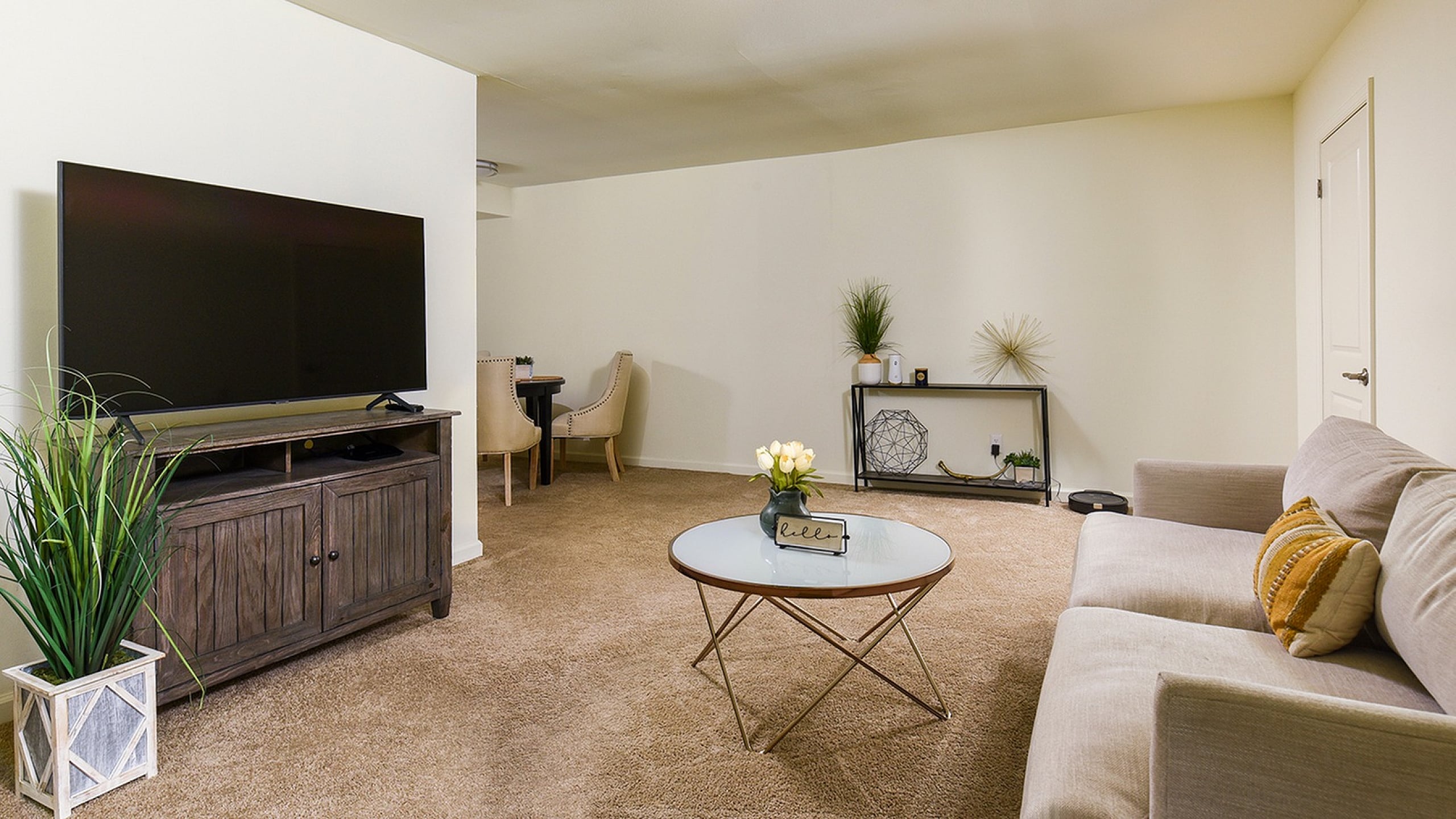 Inviting living space with a cozy sofa, stylish decor, flat-screen TV, and a chic coffee table, perfect for relaxation and entertainment.
