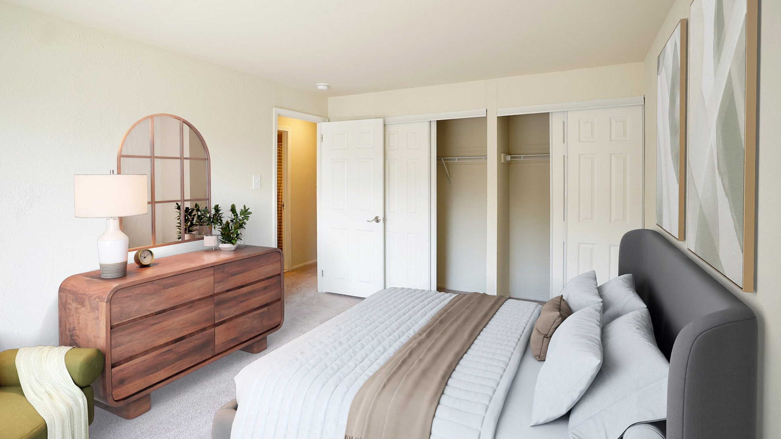 Elegant bedroom featuring a cozy bed, modern dresser with mirror, and spacious closet in a warm, inviting atmosphere.