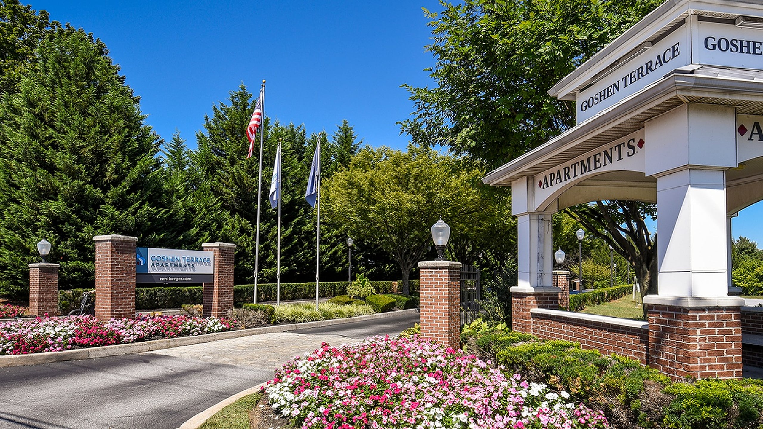 Charming Goshen Terrace entrance with elegant signage, manicured gardens, and welcoming curb appeal.