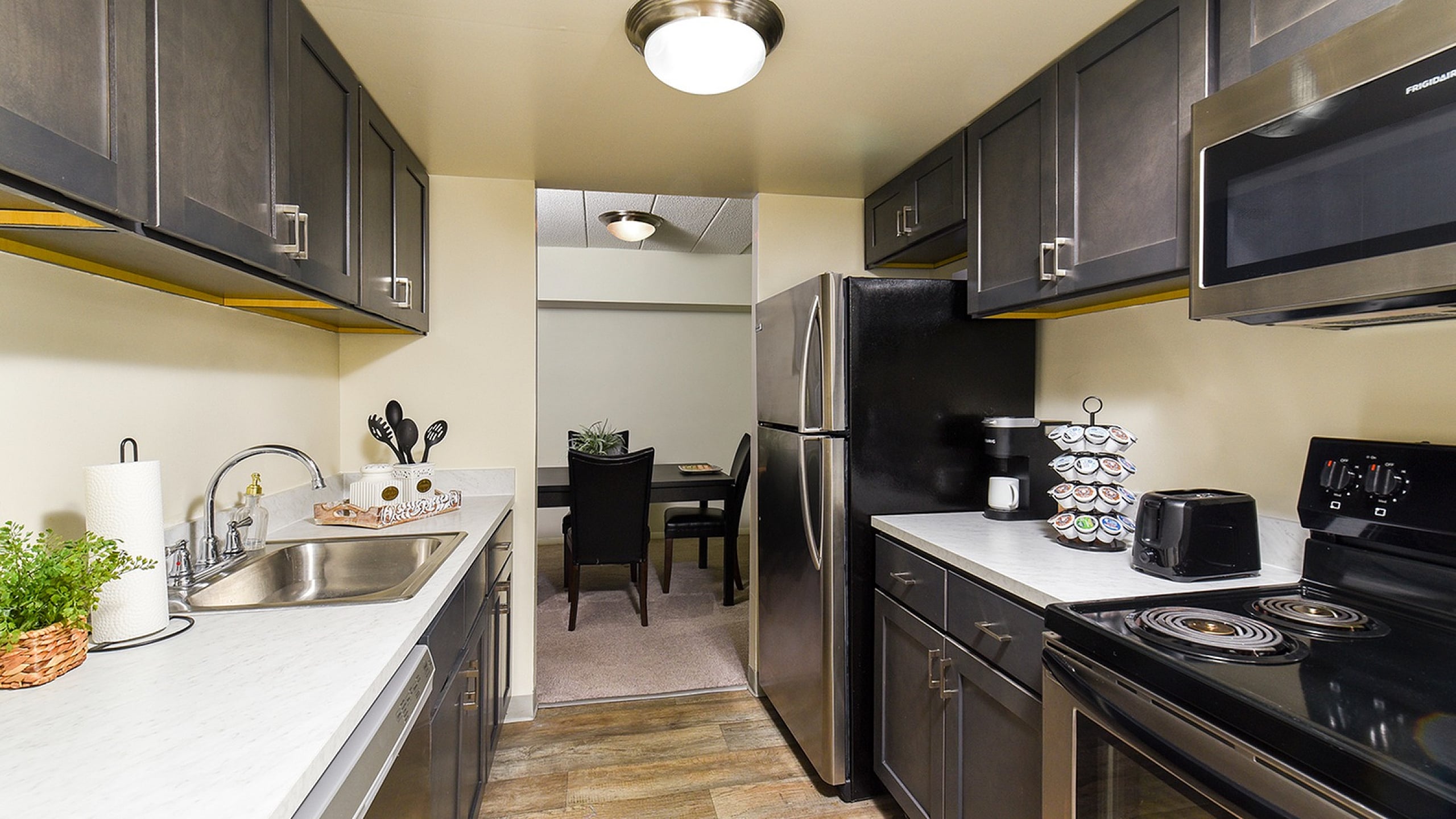 Contemporary kitchen with sleek dark cabinets, modern appliances, and a cozy dining area.