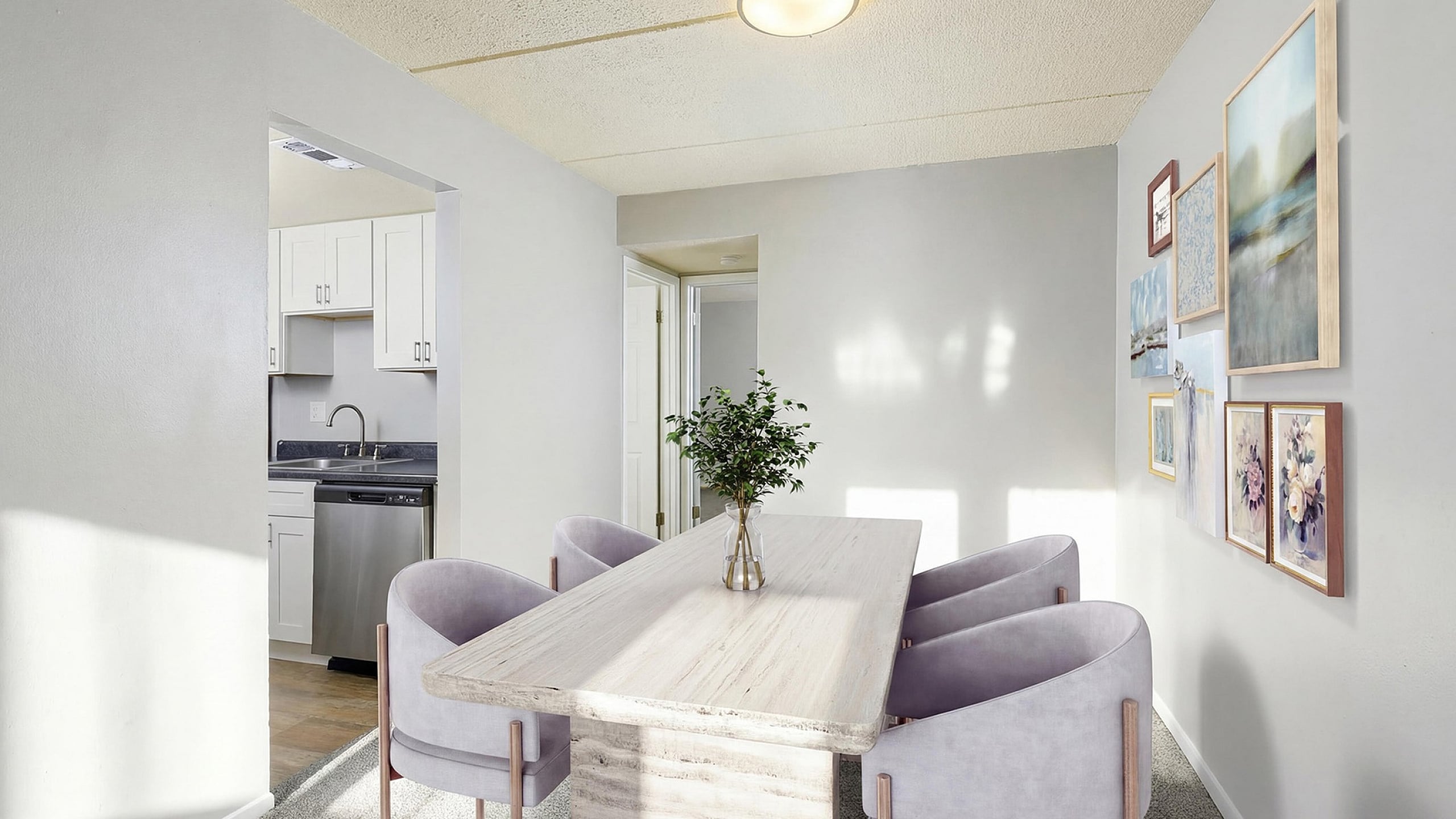 Chic dining area with elegant decor, contemporary table, and plush chairs, adjacent to a modern kitchen with white cabinetry.