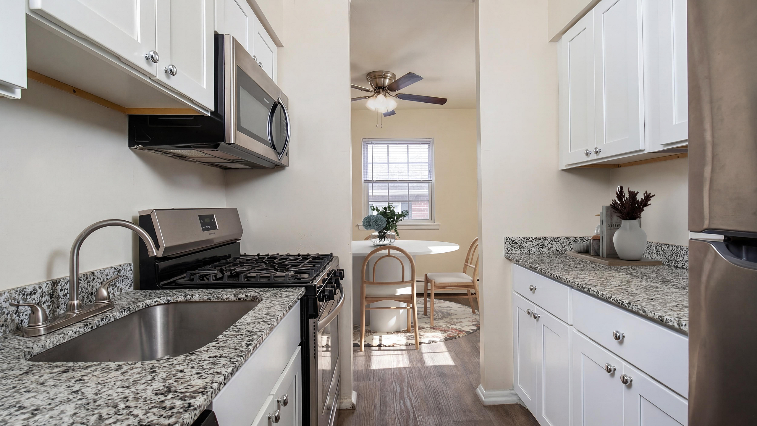 Bright and modern kitchen featuring elegant granite countertops, stainless steel appliances, and a cozy dining area with natural light.
