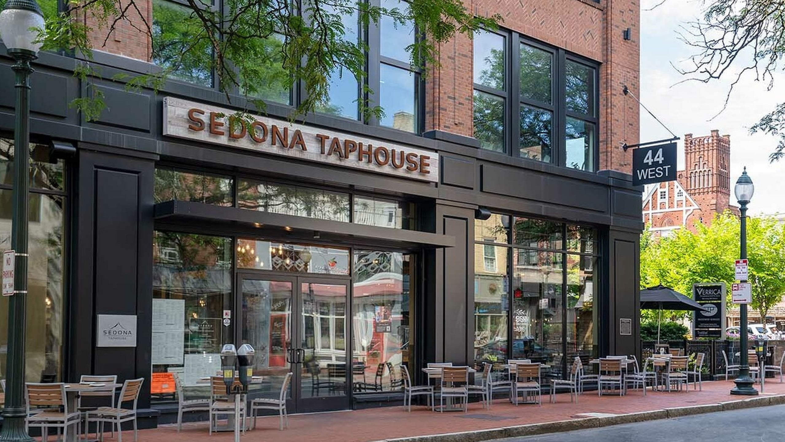 Charming urban view of Sedona Taphouse with inviting outdoor seating, nestled in a vibrant neighborhood setting.