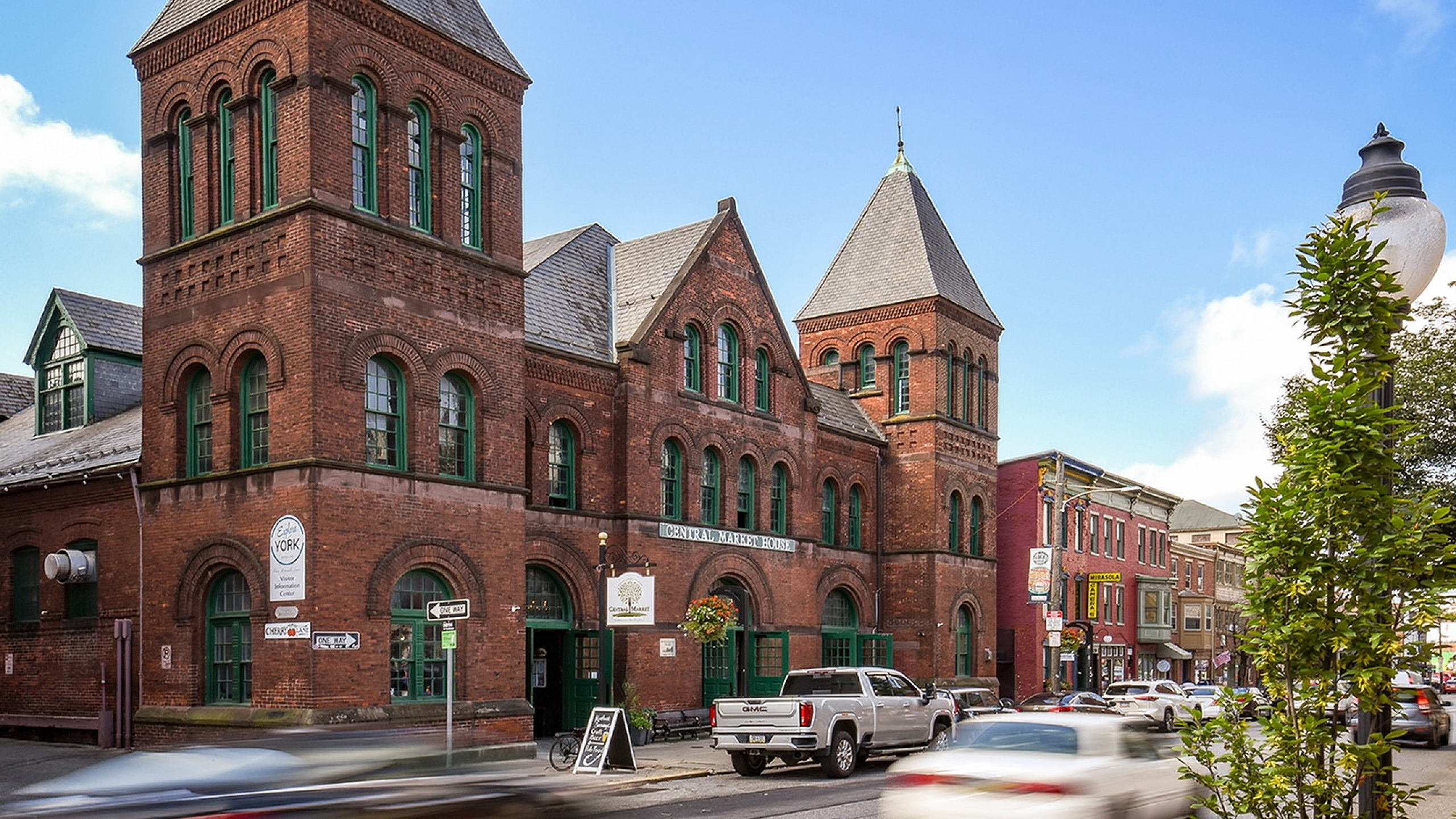 Charming historic brick building with arched windows in a vibrant urban setting, offering a unique blend of classic architecture and modern city life.