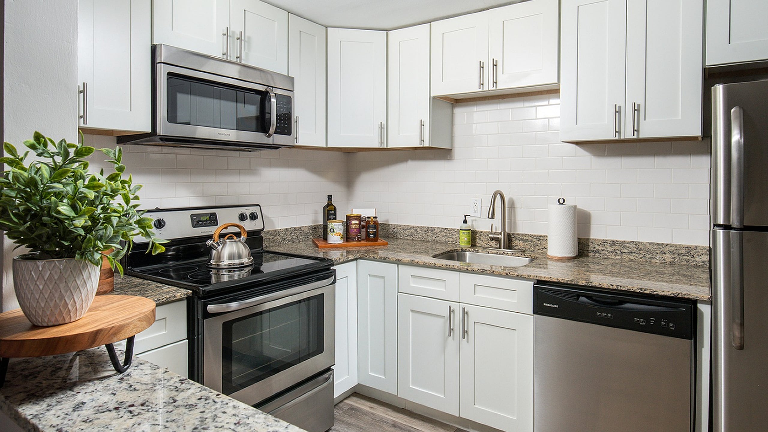 Sleek modern kitchen with white cabinets, stainless steel appliances, and granite countertops showcasing a stylish, contemporary design.
