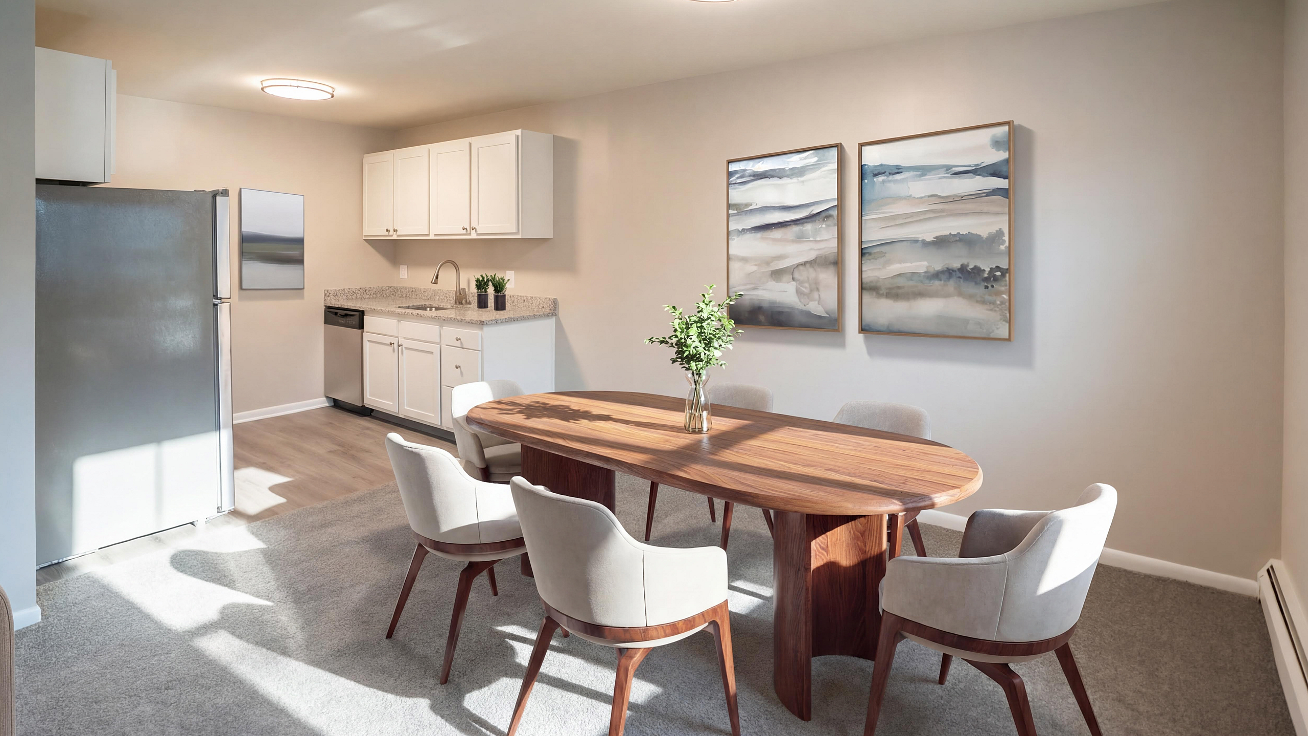 Chic dining area with elegant wooden table, plush chairs, modern kitchen, and stylish artwork in a bright, airy apartment setting.