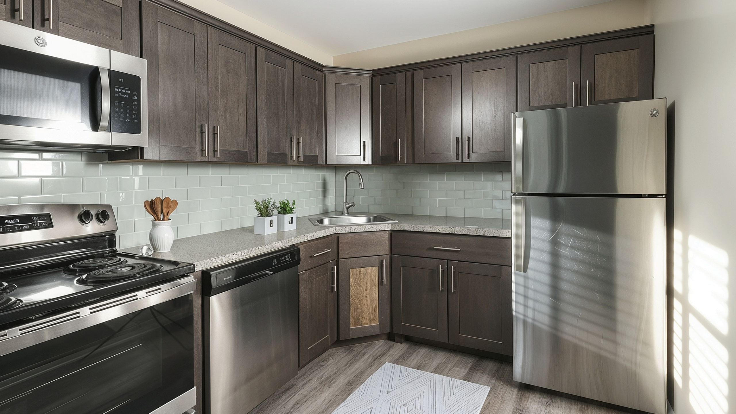 Modern kitchen with sleek dark wood cabinets, stainless steel appliances, and stylish subway tile backsplash.