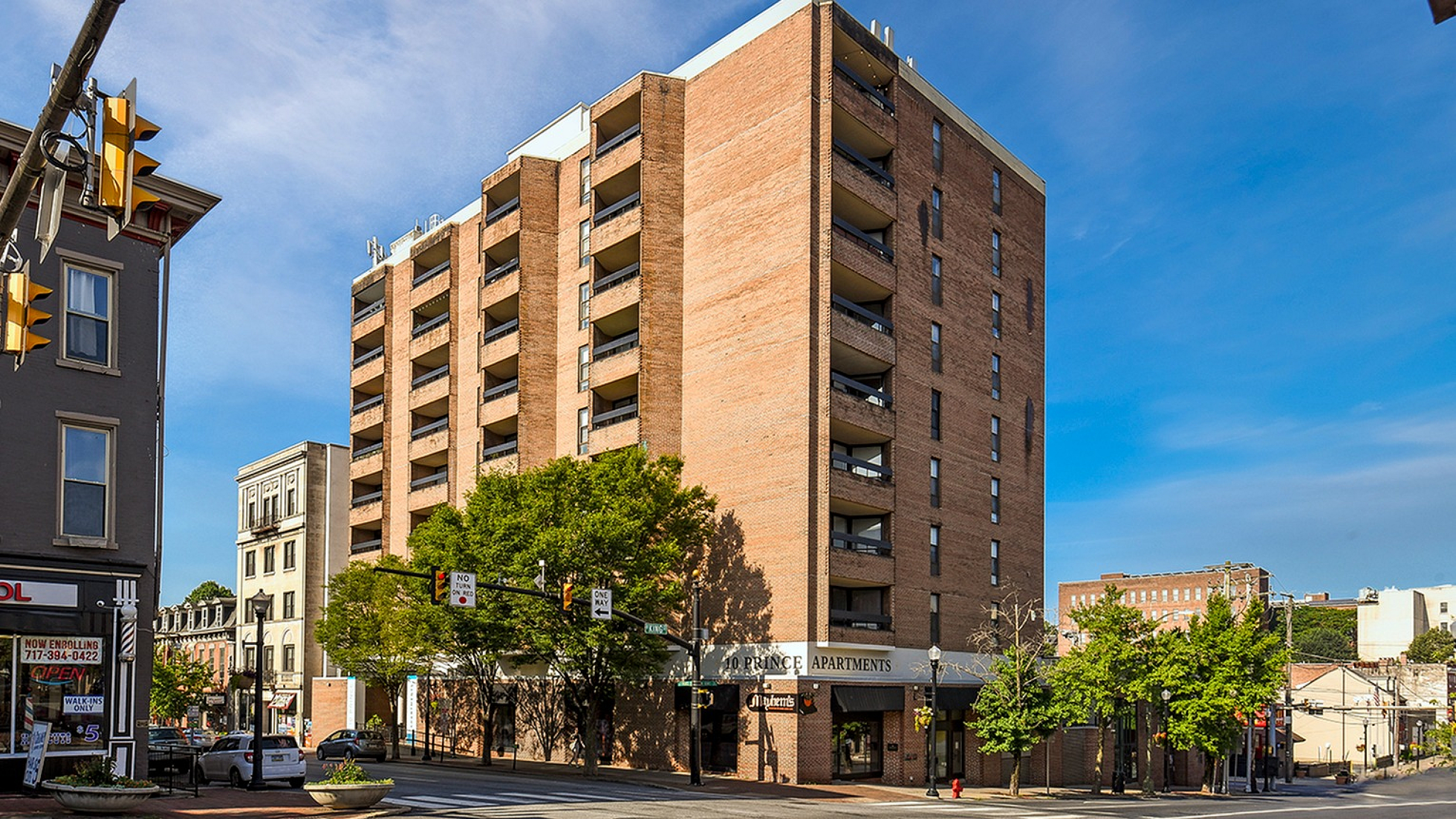 Charming urban apartment building showcasing modern architecture, ample balconies, and a vibrant neighborhood setting.