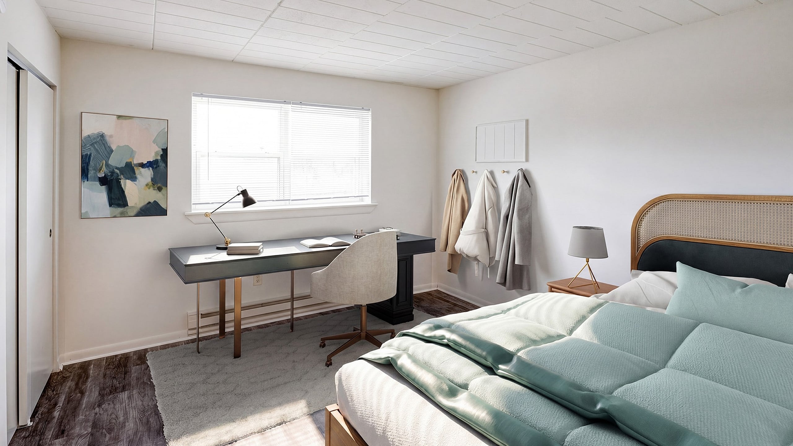Bright and airy bedroom with modern desk setup, stylish wall art, cozy bedding, and ample natural light.