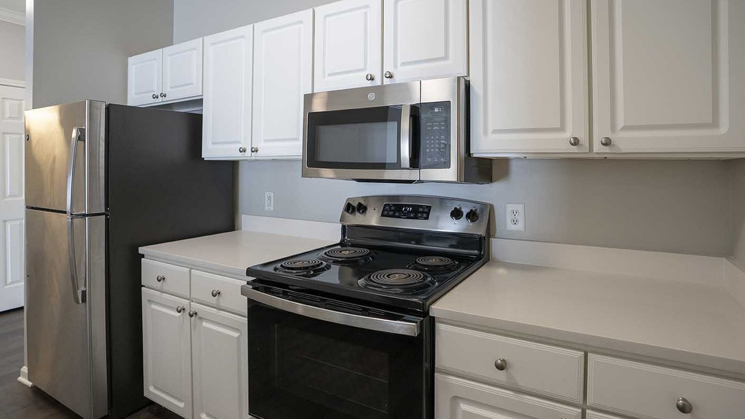 Modern kitchen with sleek stainless steel appliances, elegant white cabinetry, and spacious countertops.
