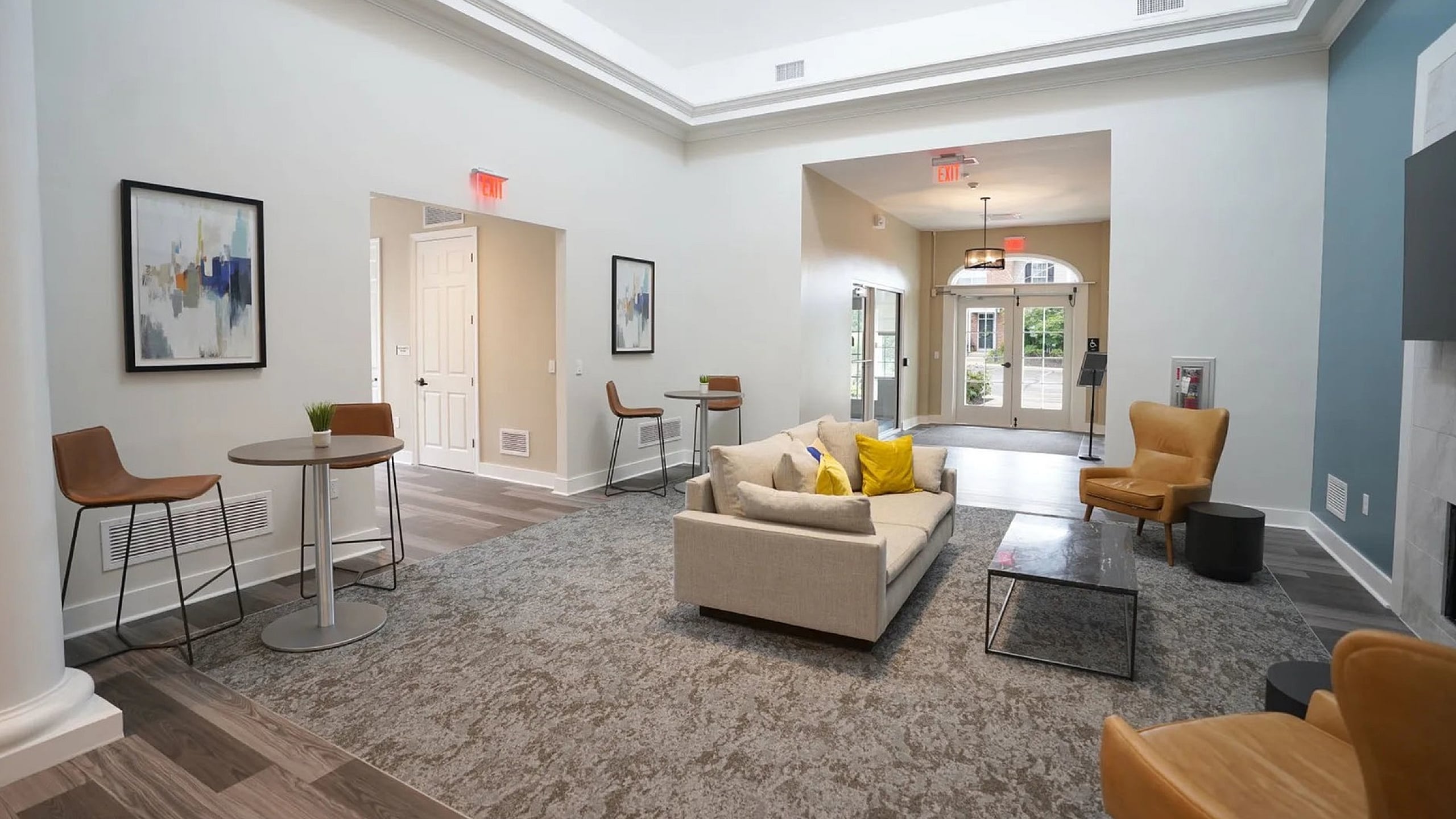 Modern lounge area with stylish seating, vibrant artwork, and abundant natural light creating a welcoming space.