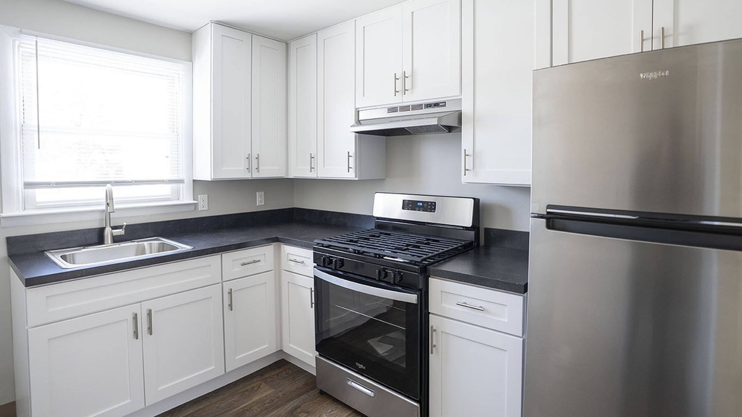 Modern kitchen with sleek white cabinets, stainless steel appliances, and elegant countertops, offering a bright, contemporary feel.
