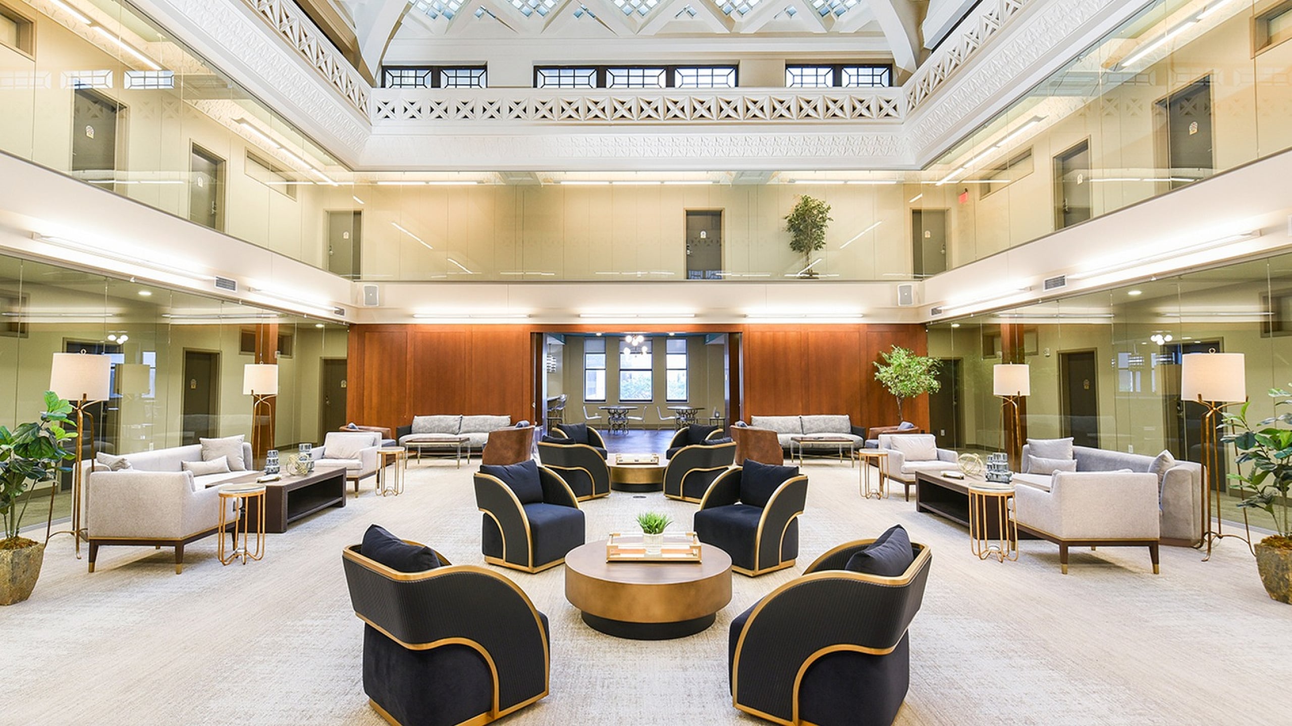 Luxurious atrium lounge featuring elegant seating arrangements under a grand vaulted ceiling with geometric skylights.