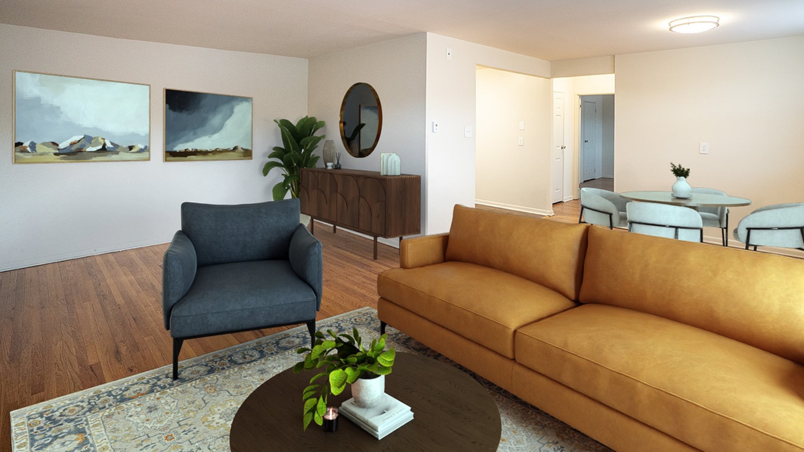 Inviting living room with modern decor, featuring a stylish leather sofa, contemporary armchair, and elegant artwork on the walls. Perfect for relaxing or entertaining.