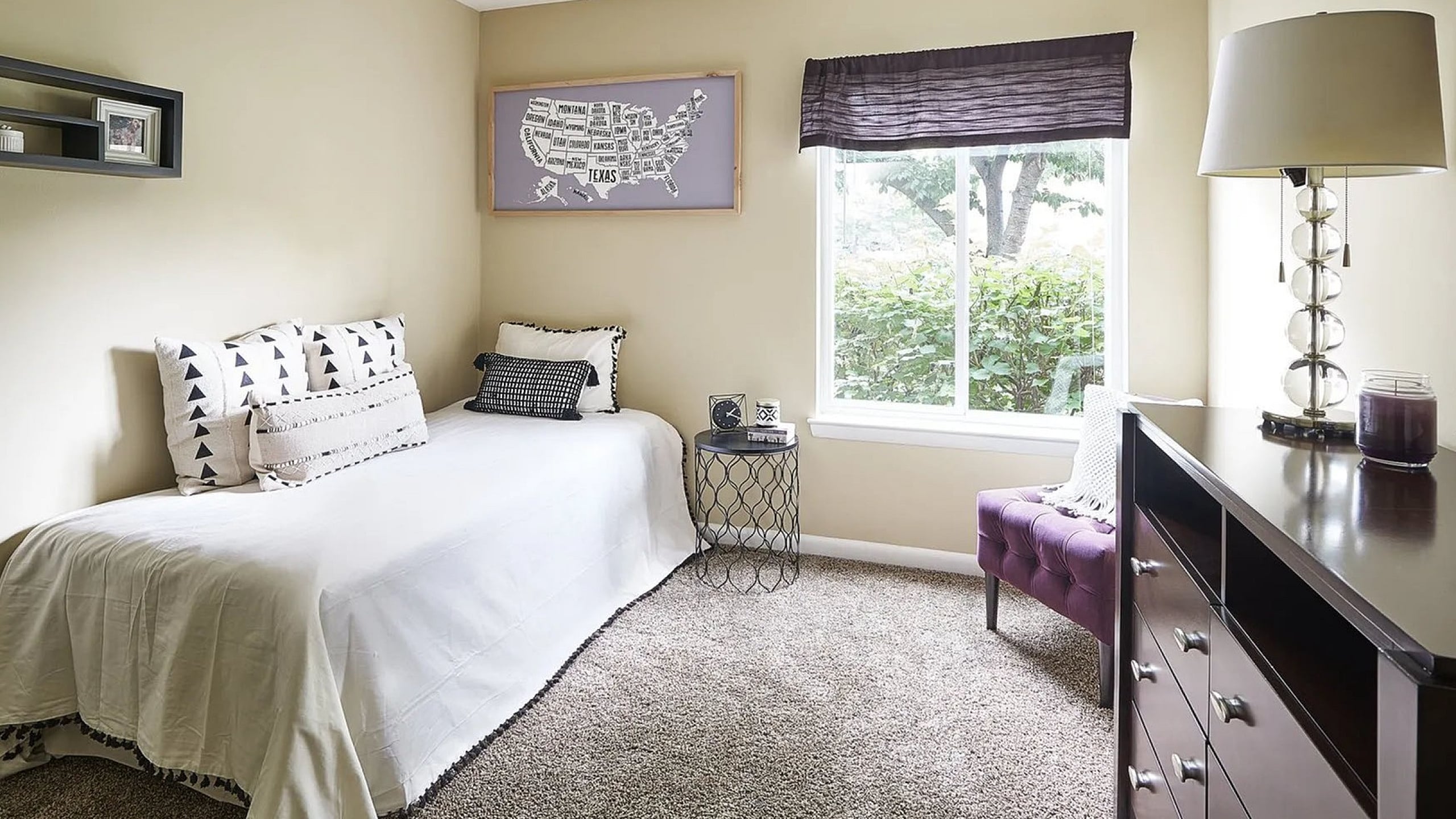 Chic bedroom with abundant natural light, cozy daybed, and elegant decor, perfect for serene living.