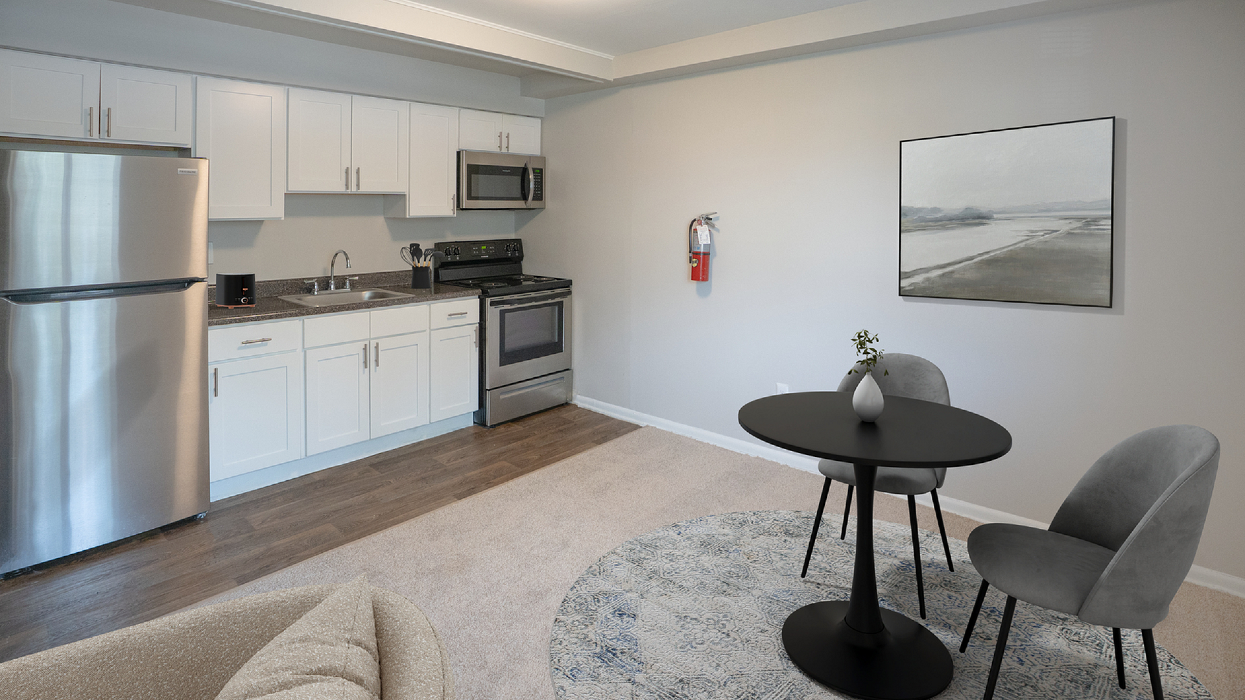 Modern open-plan kitchen and dining area with sleek stainless steel appliances and elegant furnishings.